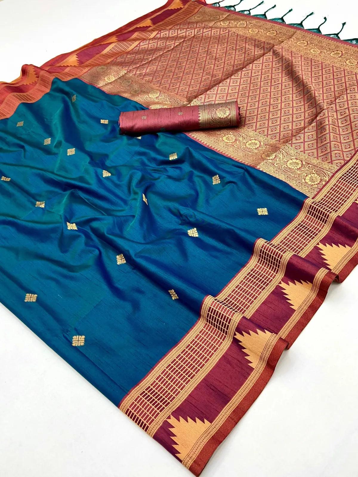 Close-up of Tarani blue silk saree with golden motifs and maroon pallu detailing