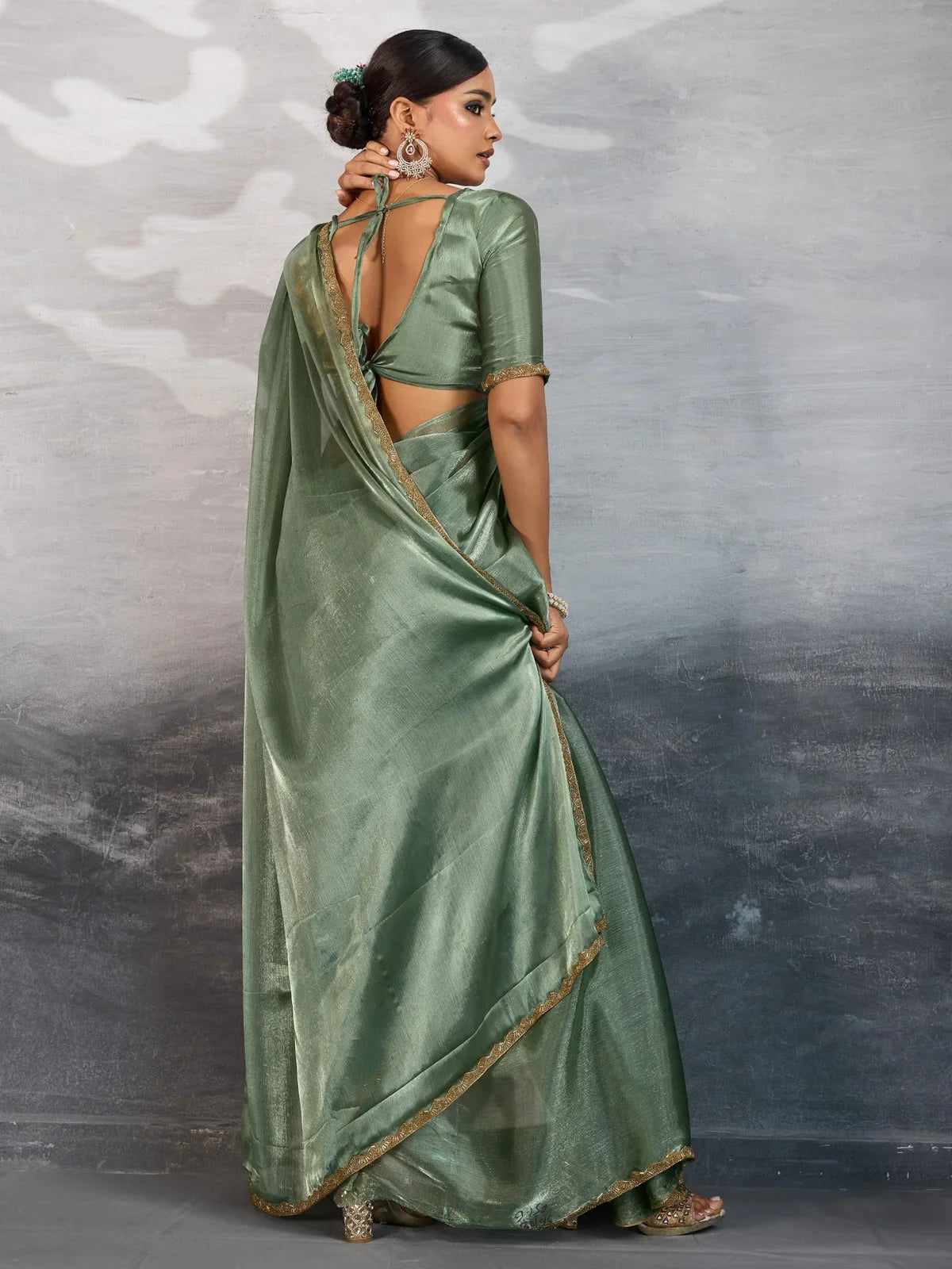 Tarani green chiffon saree back view highlighting blouse back design and lace border