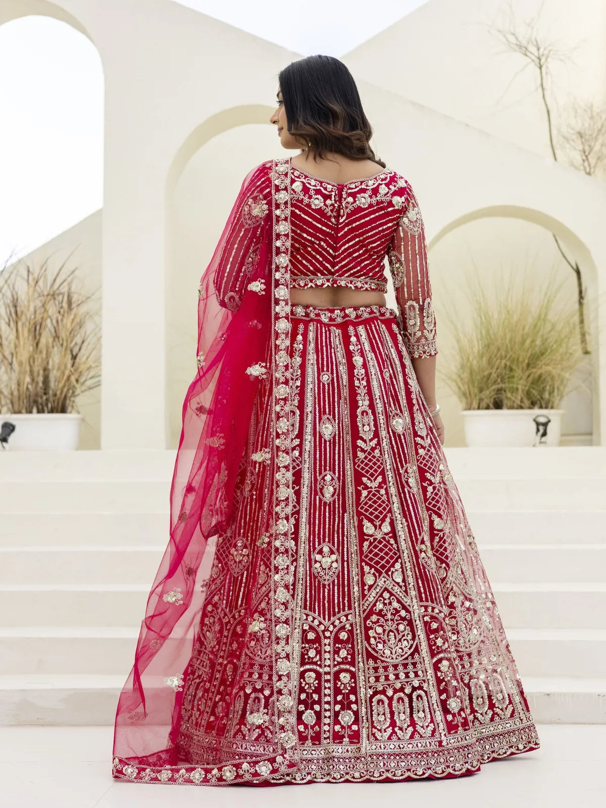 Back view of Tarani red butterfly net lehenga with intricate embroidery and full flare
