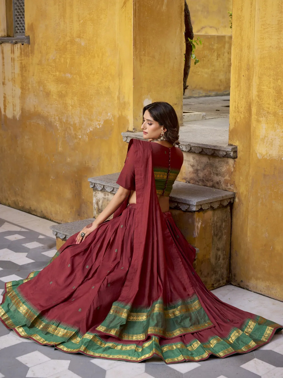 Tarani back view of maroon Chanderi lehenga showing flare and golden border detailing