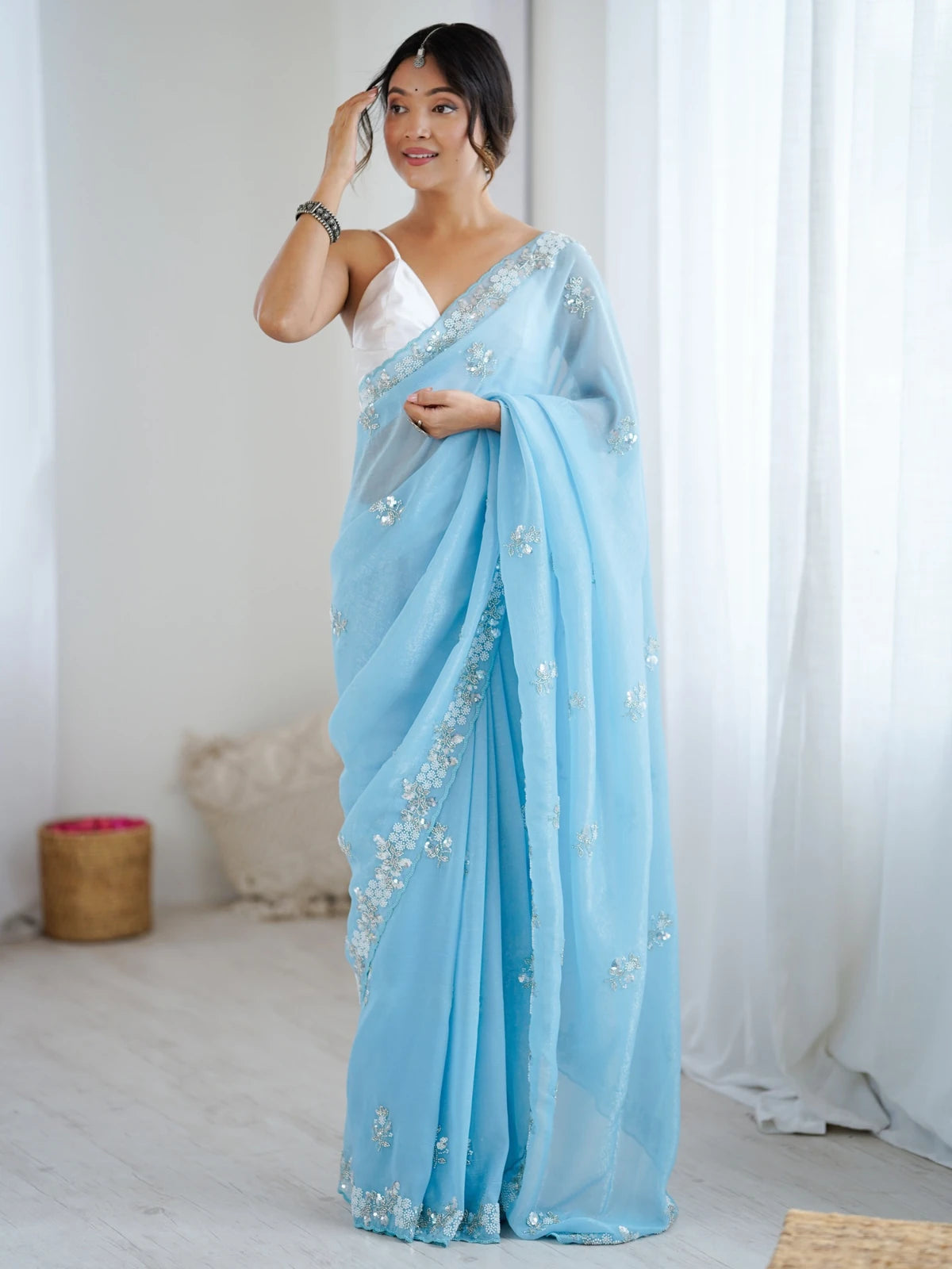 Tarani sky blue chiffon crush saree side pose showing embellished border and graceful style