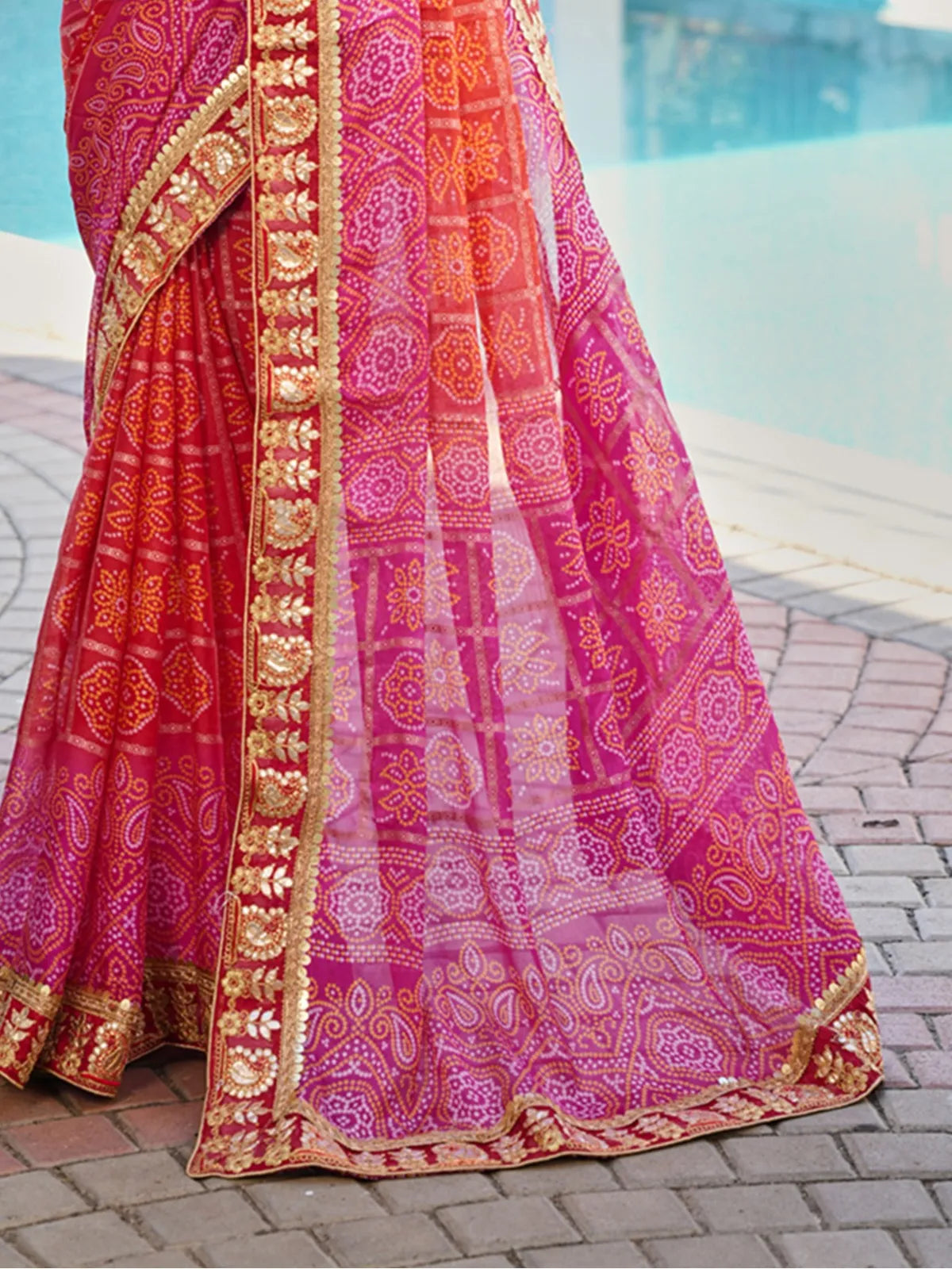 Closeup of Tarani pink chiffon saree with golden border and bandhani design