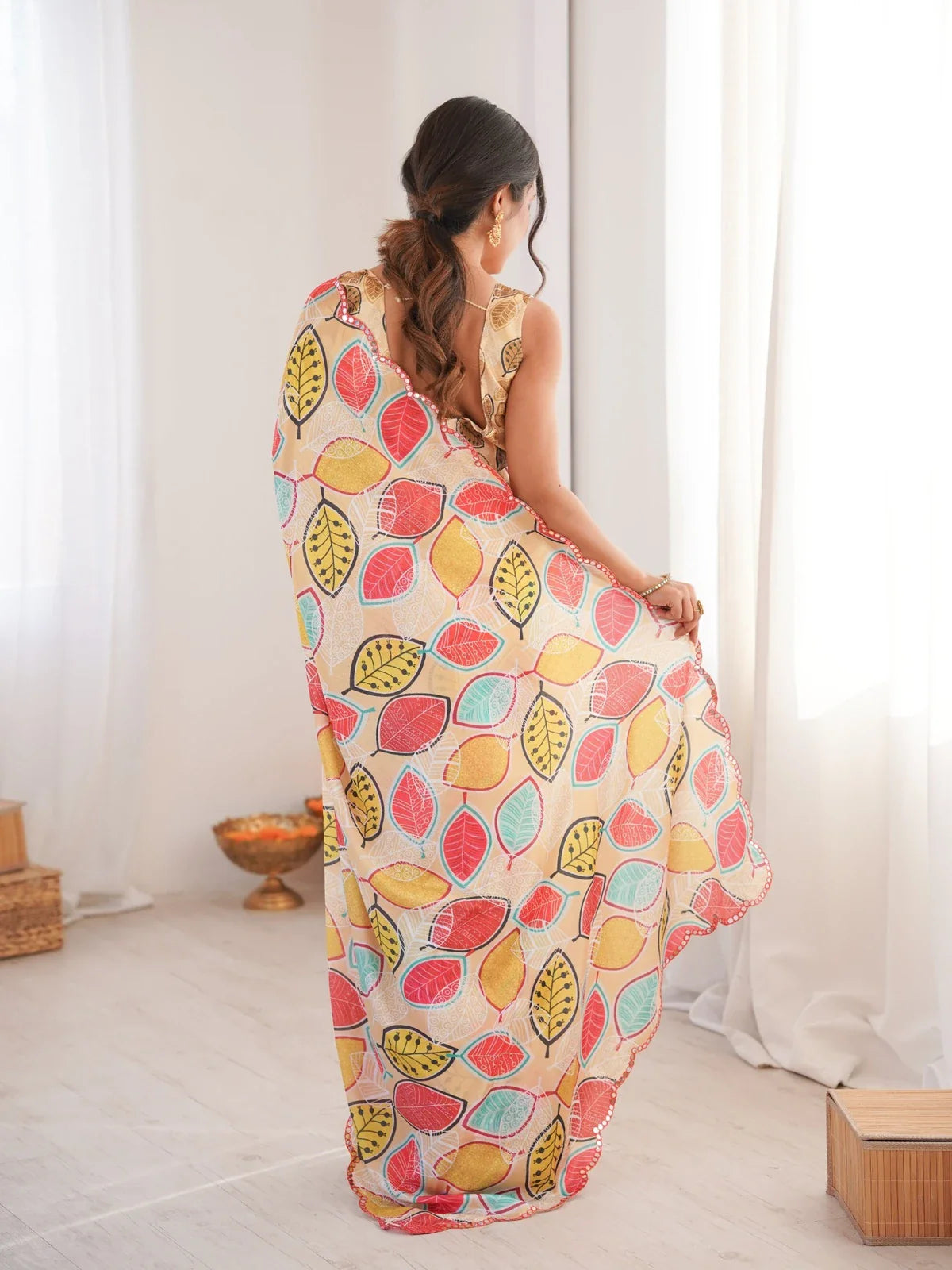 Back pose of Hema in Tarani Chinnon saree with flowing pallu and printed back blouse view