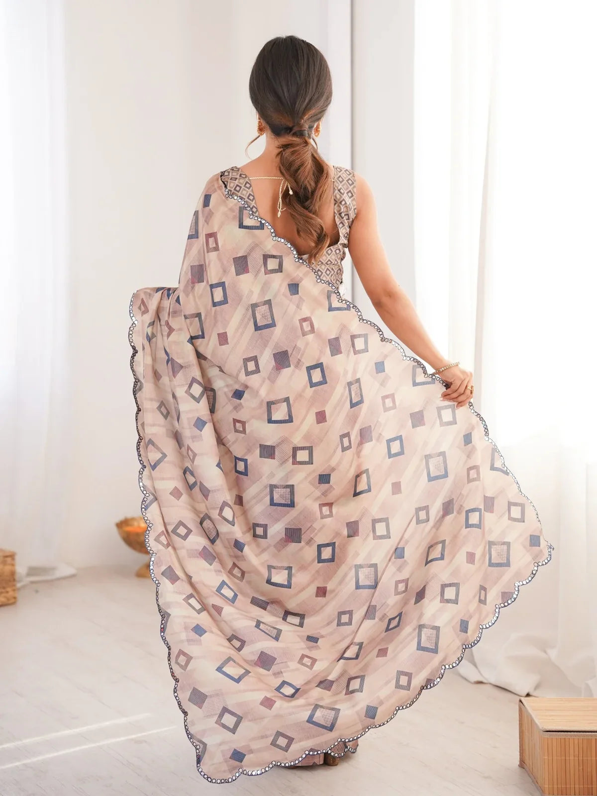 Tarani back view showing blouse design and flowy pallu of beige saree