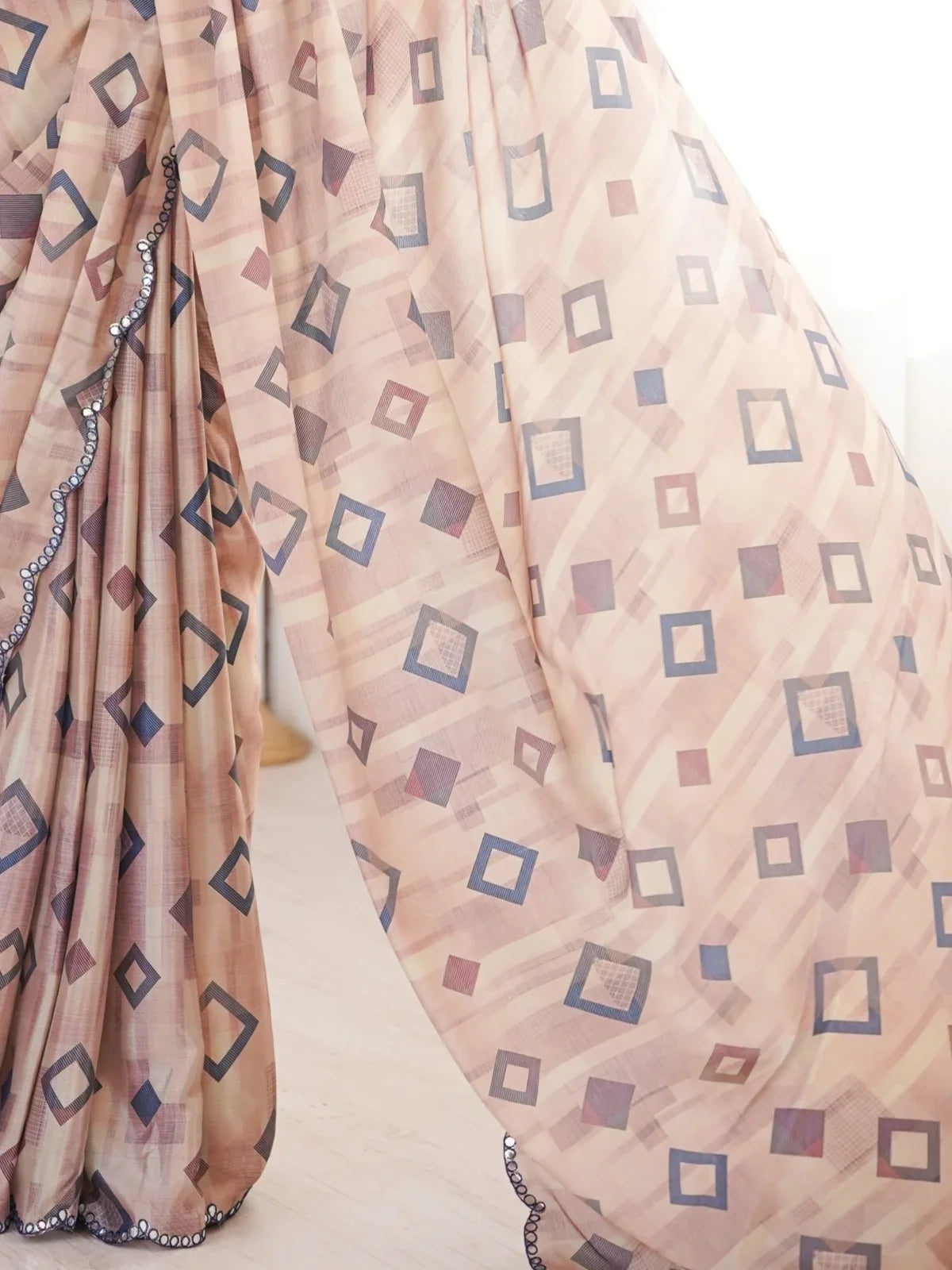 Tarani pallu view of beige chinnon saree with mirror border