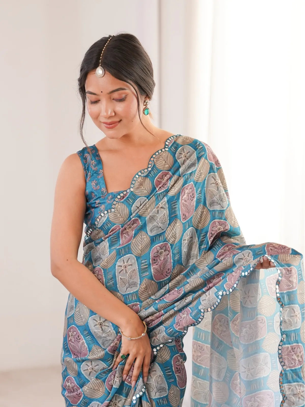 Tarani chinnon saree close-up showing blue printed pattern and mirror work on upper body