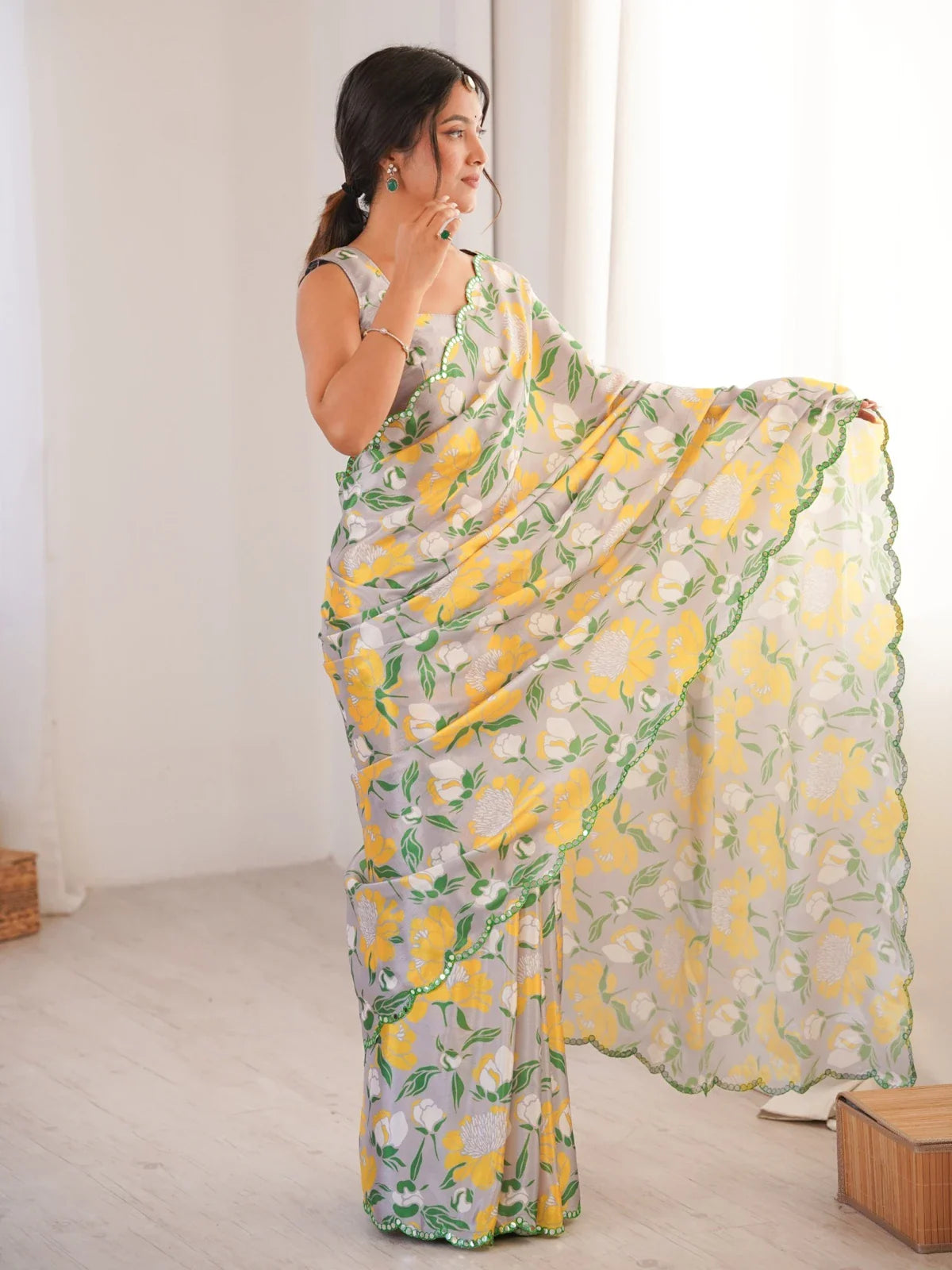 Pallu view of Tarani chinnon saree with vibrant yellow floral motifs and green mirror border