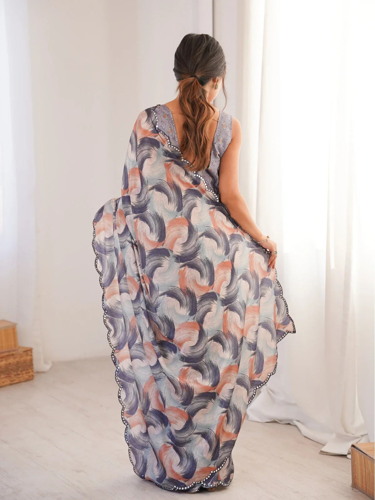 Tarani saree back view showing graceful pallu fall and scalloped edging in chinnon fabric