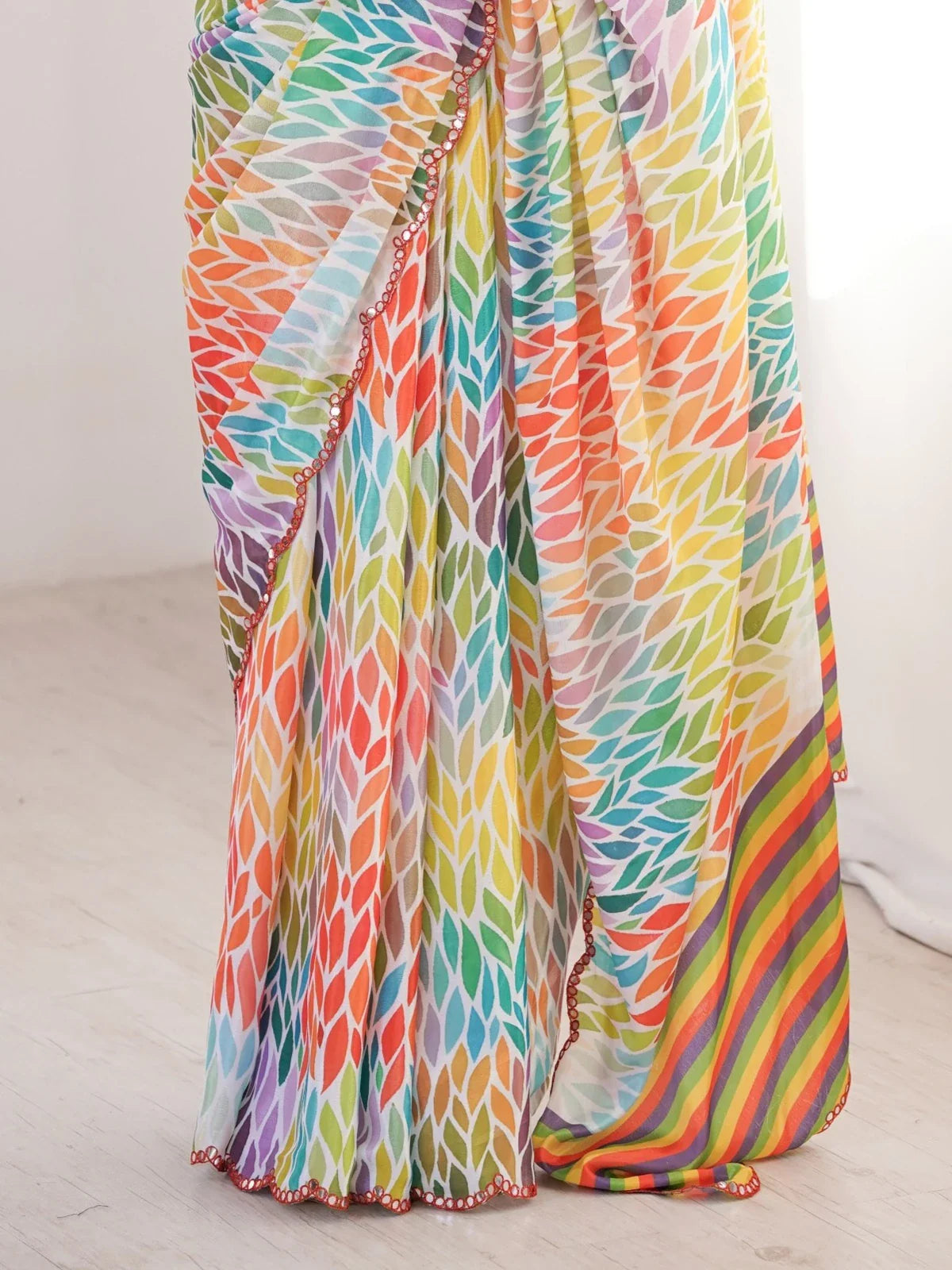 Closeup of multicolor printed chinnon saree fabric with mirror work border by Tarani