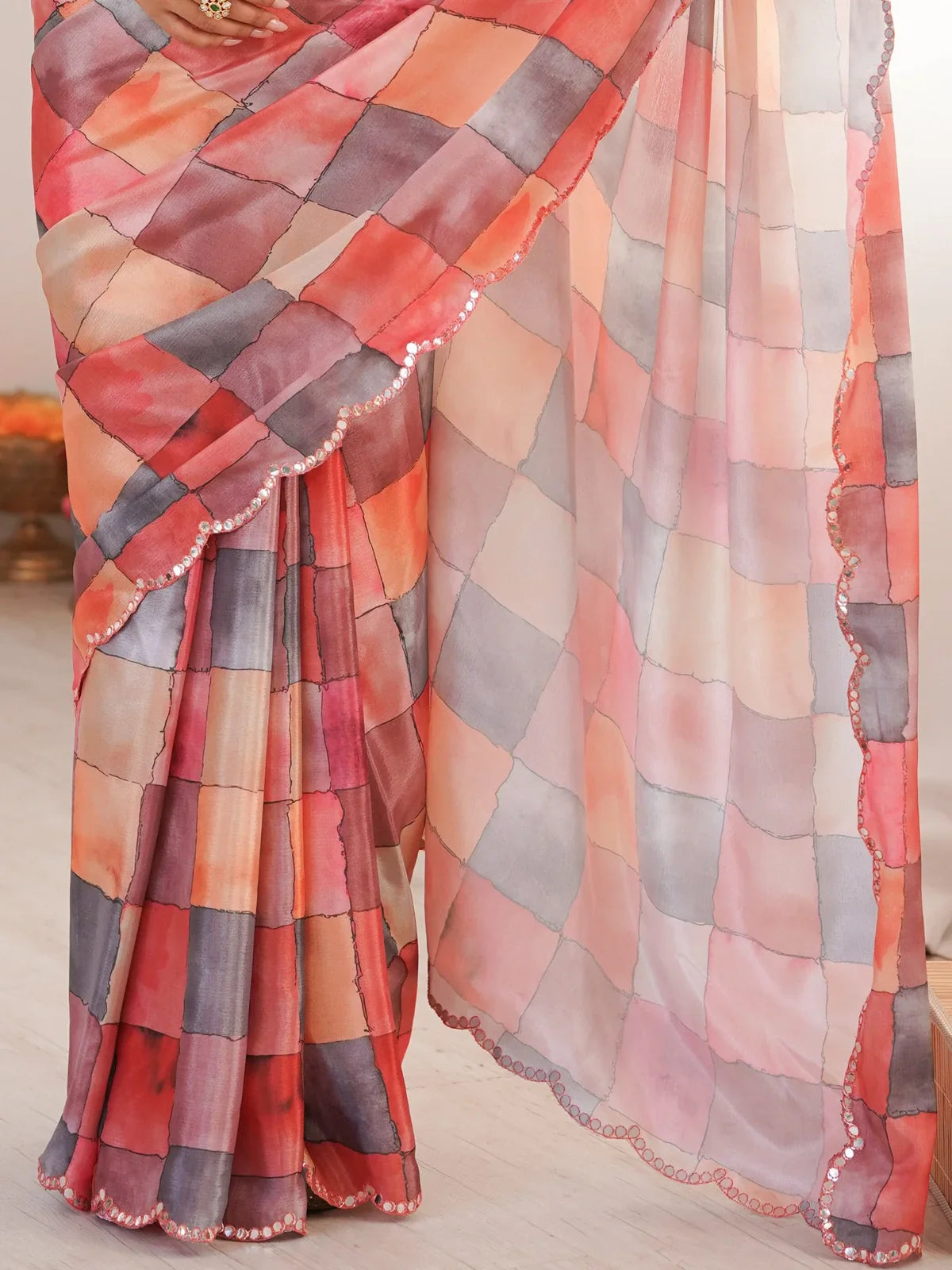 Tarani peach saree pallu view highlighting flowy fabric and mirror work lace detailing