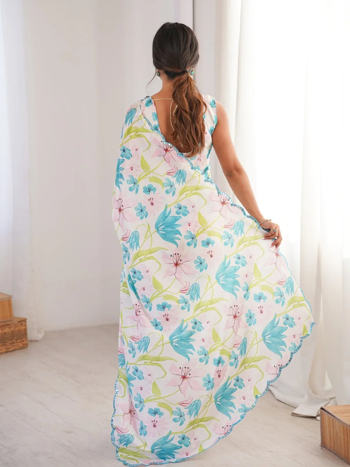 Back view of Tarani chinnon saree in floral white with scallop mirror border and sleeveless blouse