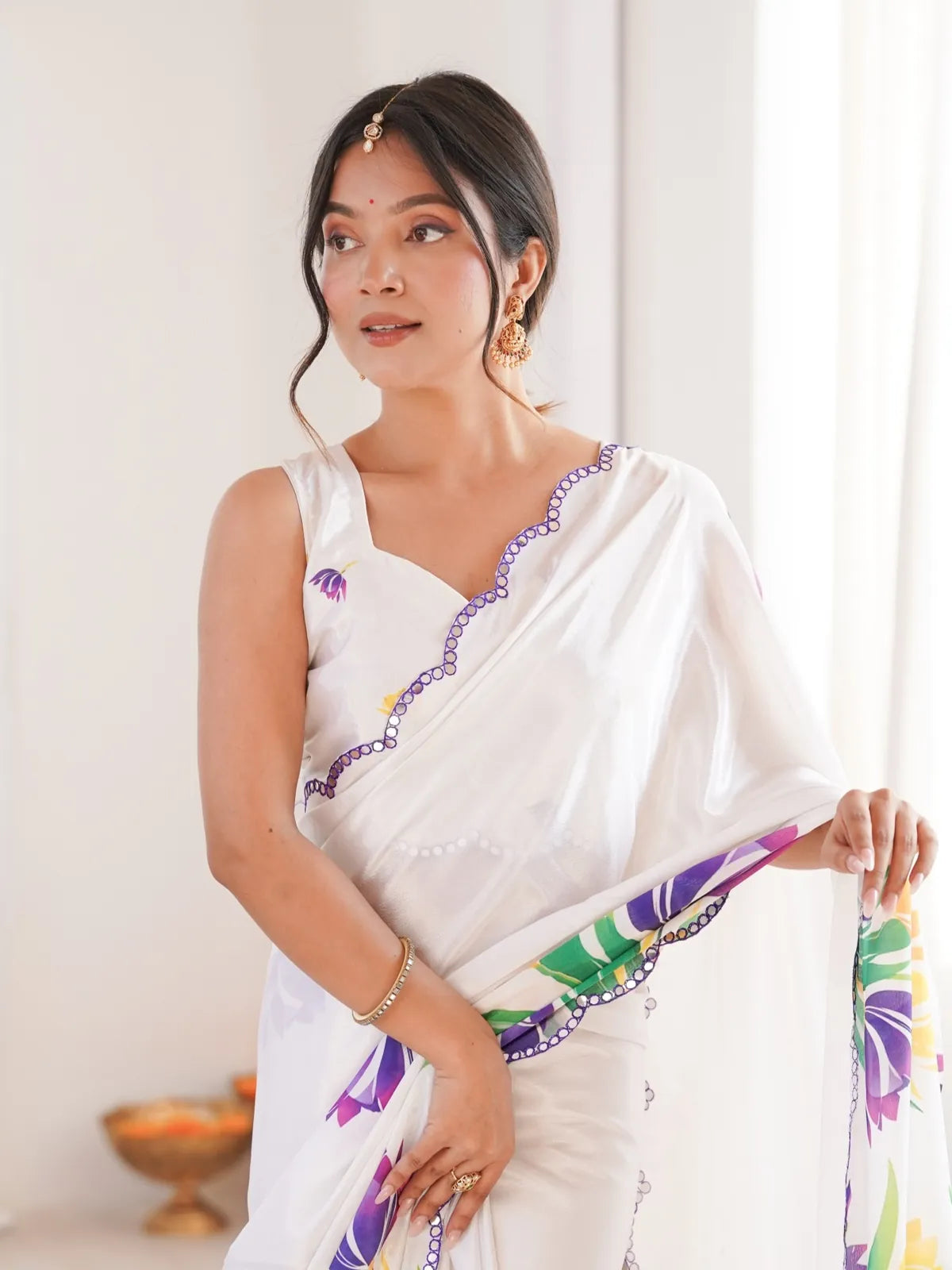 Tarani premium white saree with vibrant floral border and matching sleeveless blouse in upper-body pose