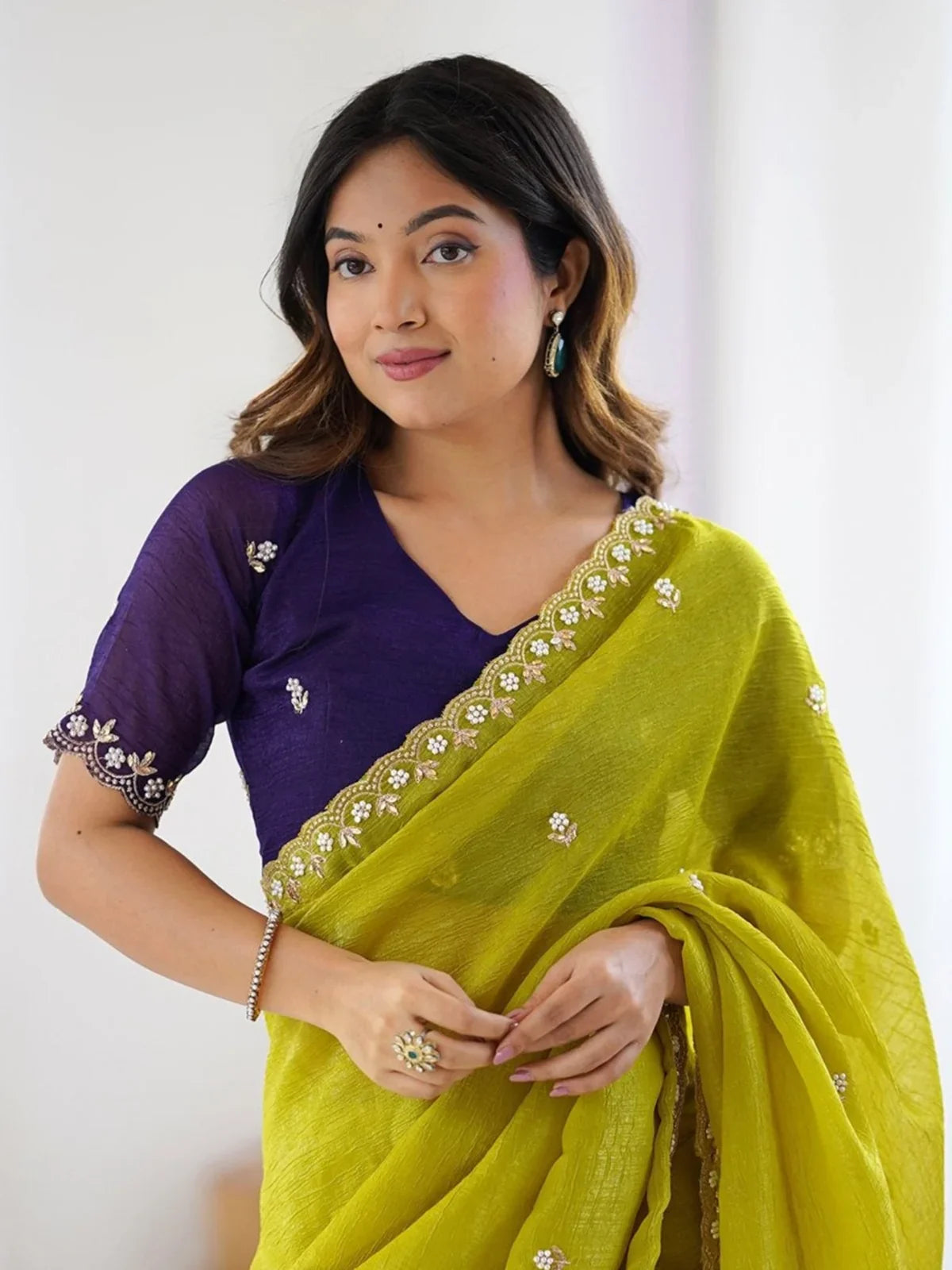 Tarani green party wear saree with purple embroidered blouse upper-body closeup