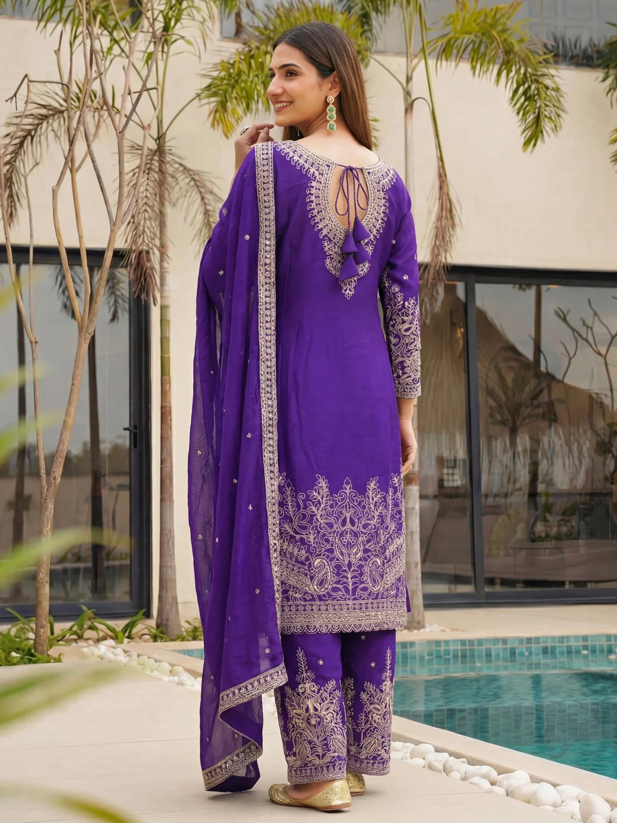 Tarani back pose of chinon silk embroidered purple sharara suit with stylish tassels