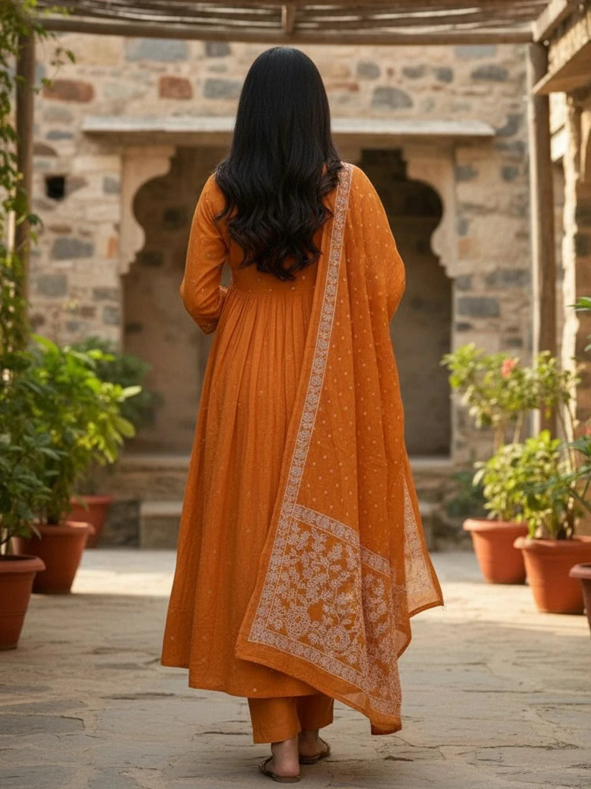 Tarani back view orange cotton dress with printed dupatta flowing behind
