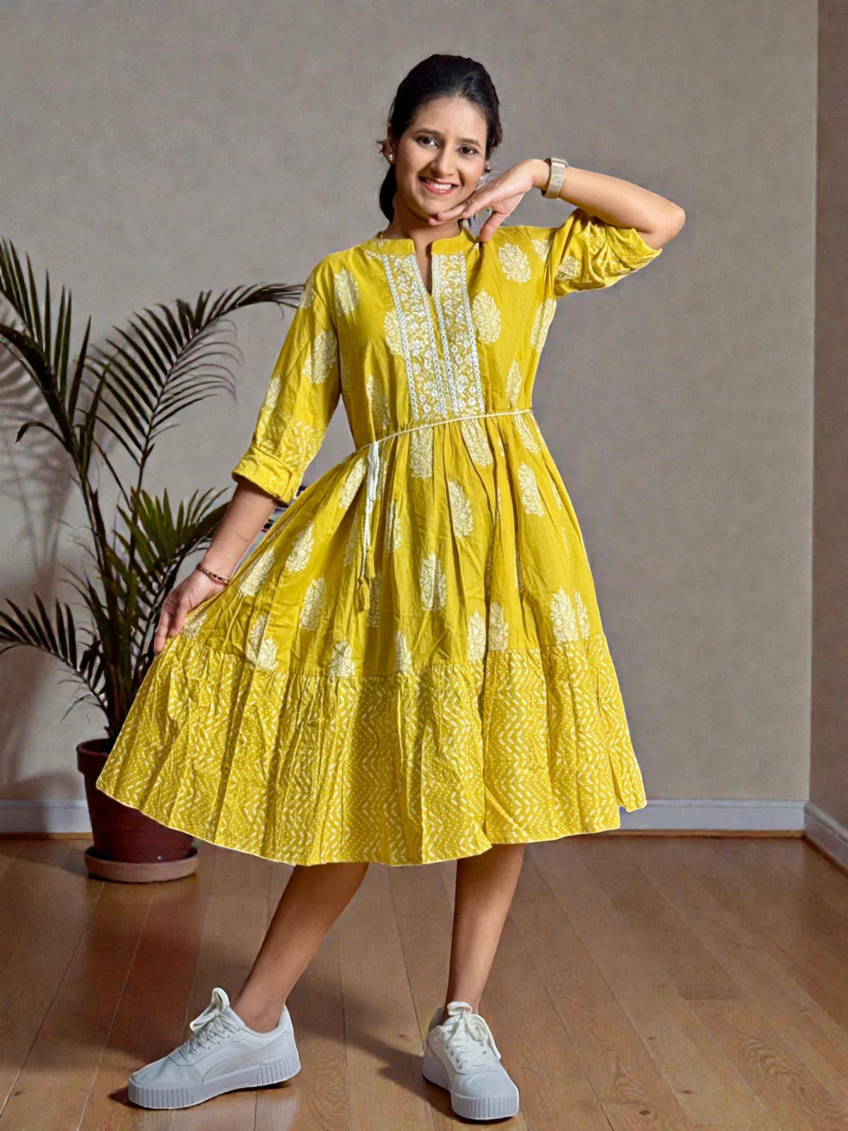 Tarani yellow dress in cotton with full view showing flowy hem and sneakers
