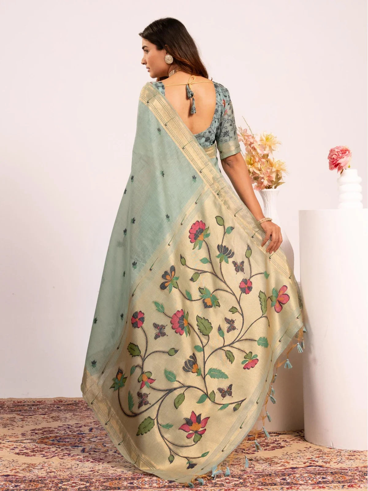 Tarani back view of contrast floral blouse with deep neckline paired with cotton paithani saree
