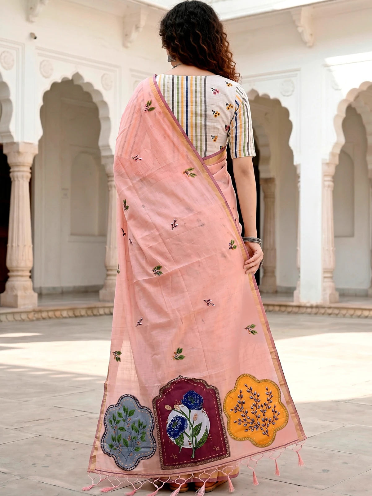 Tarani Nehika peach cotton saree back view with woven floral motifs and tassel pallu
