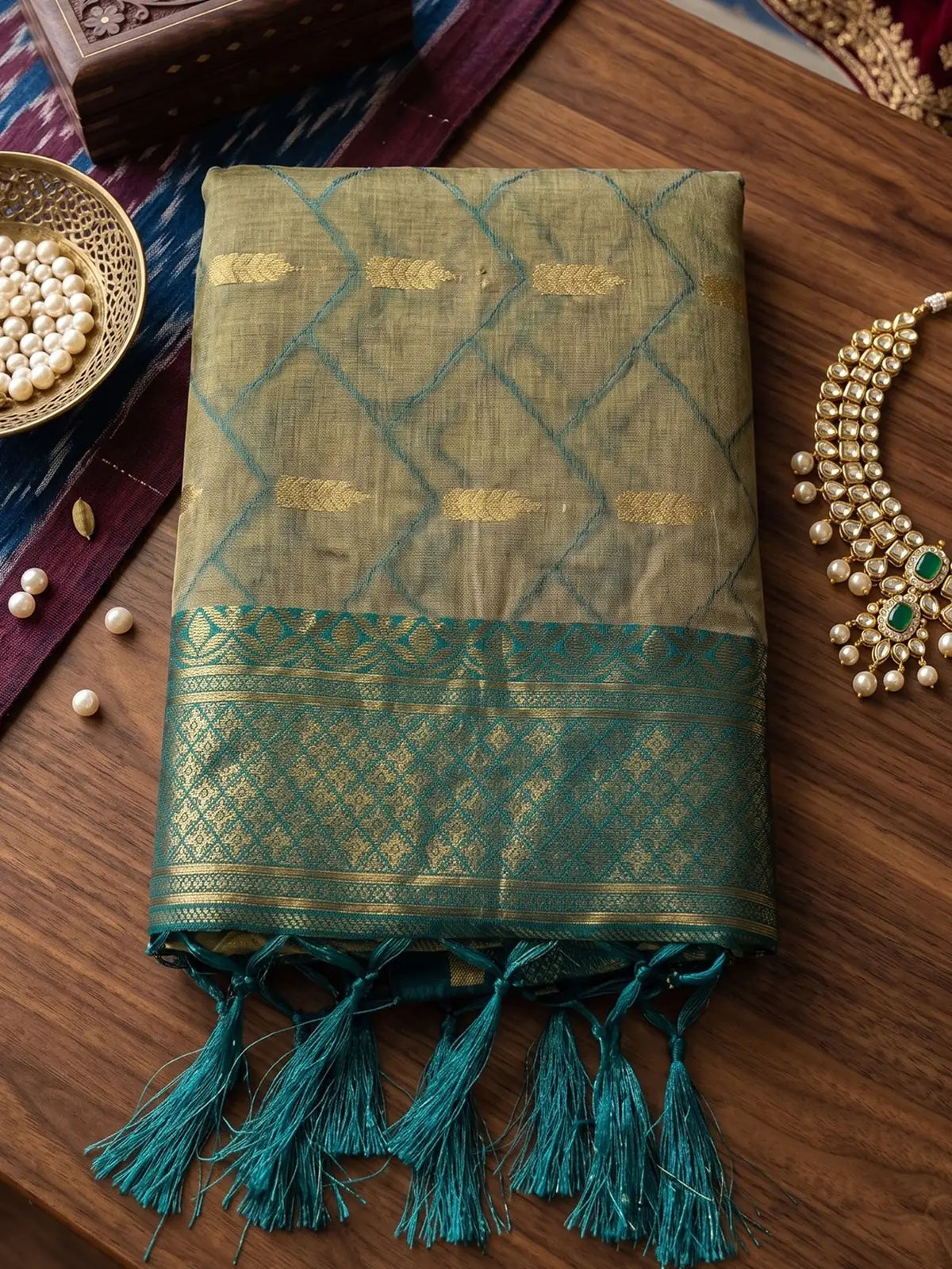 Tarani beige cotton silk saree closeup with teal zari woven border and tassel detailing