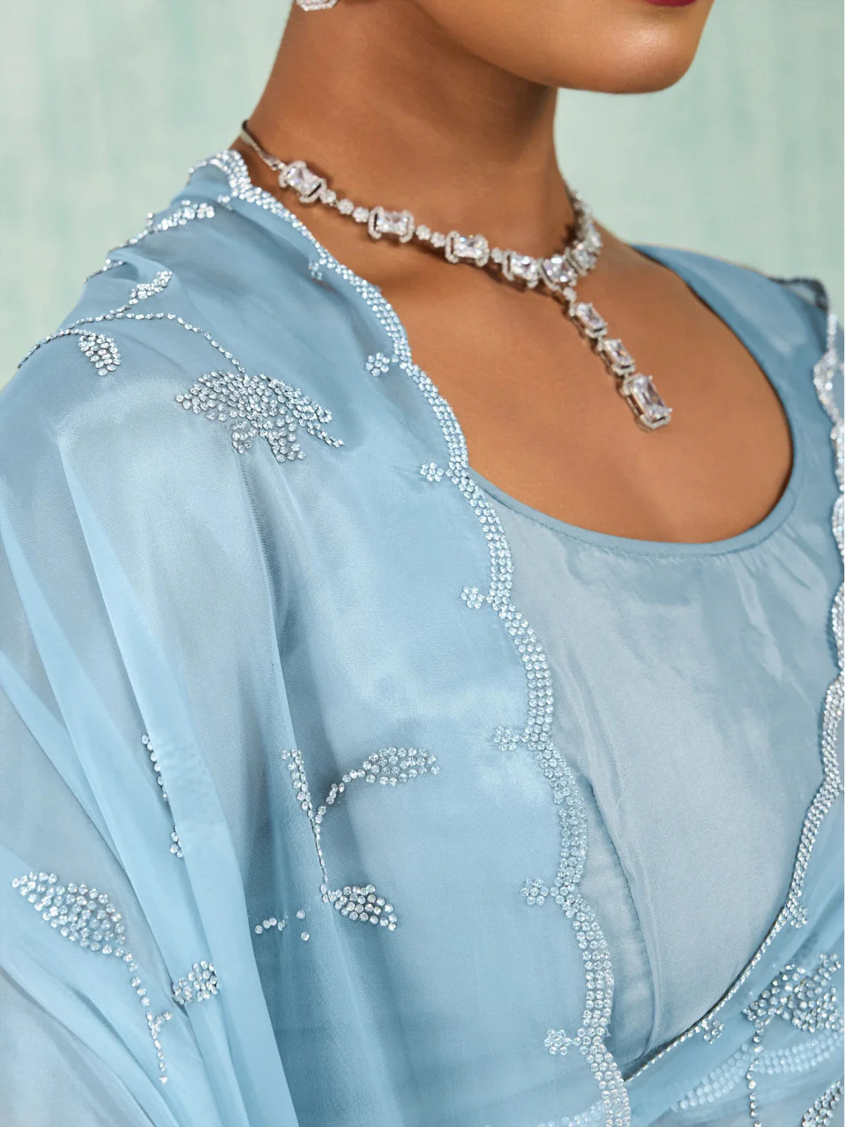 Tarani closeup view of blue crystal viscose saree showing floral zarkan embroidery and cutwork border