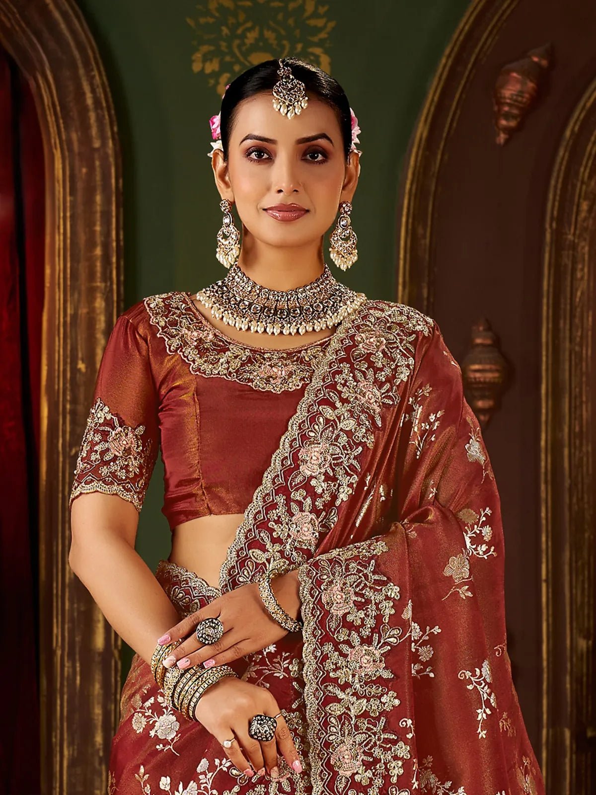 Tarani upper body view of maroon fancy saree highlighting floral embroidery and jewellery styling