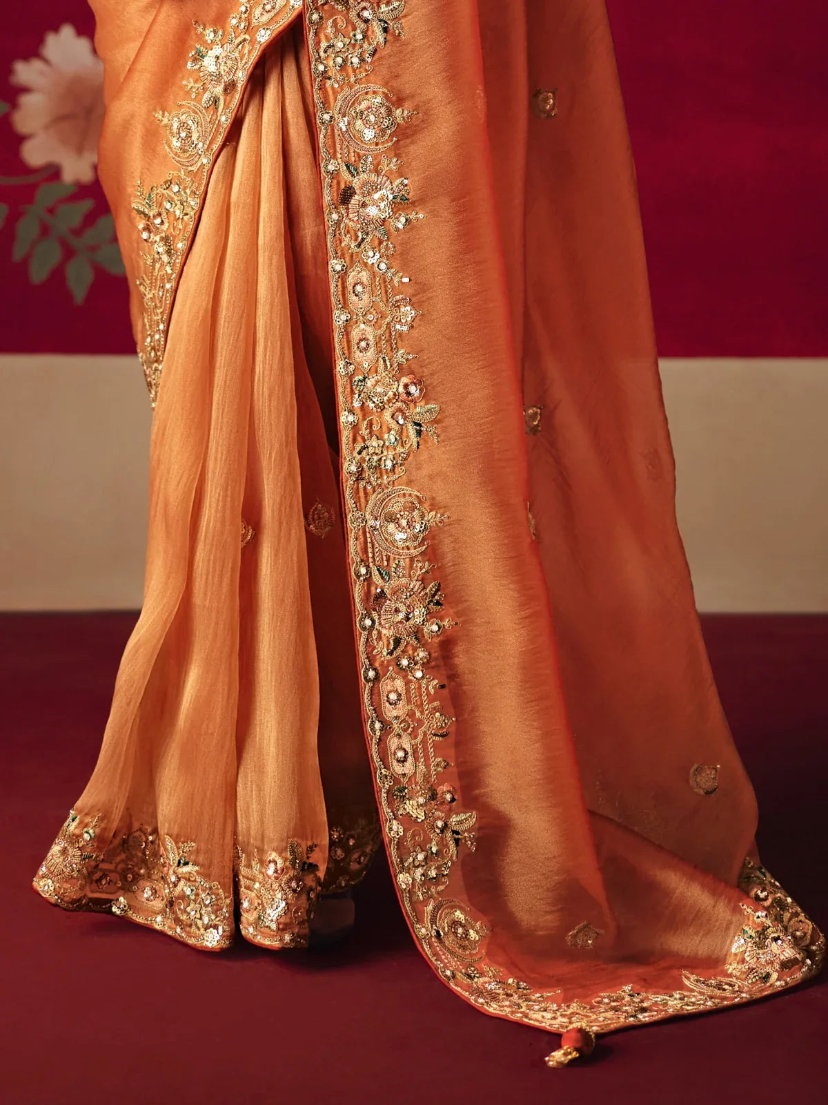 Tarani orange saree closeup highlighting intricate sequins, dhaga and thread embroidery work on border