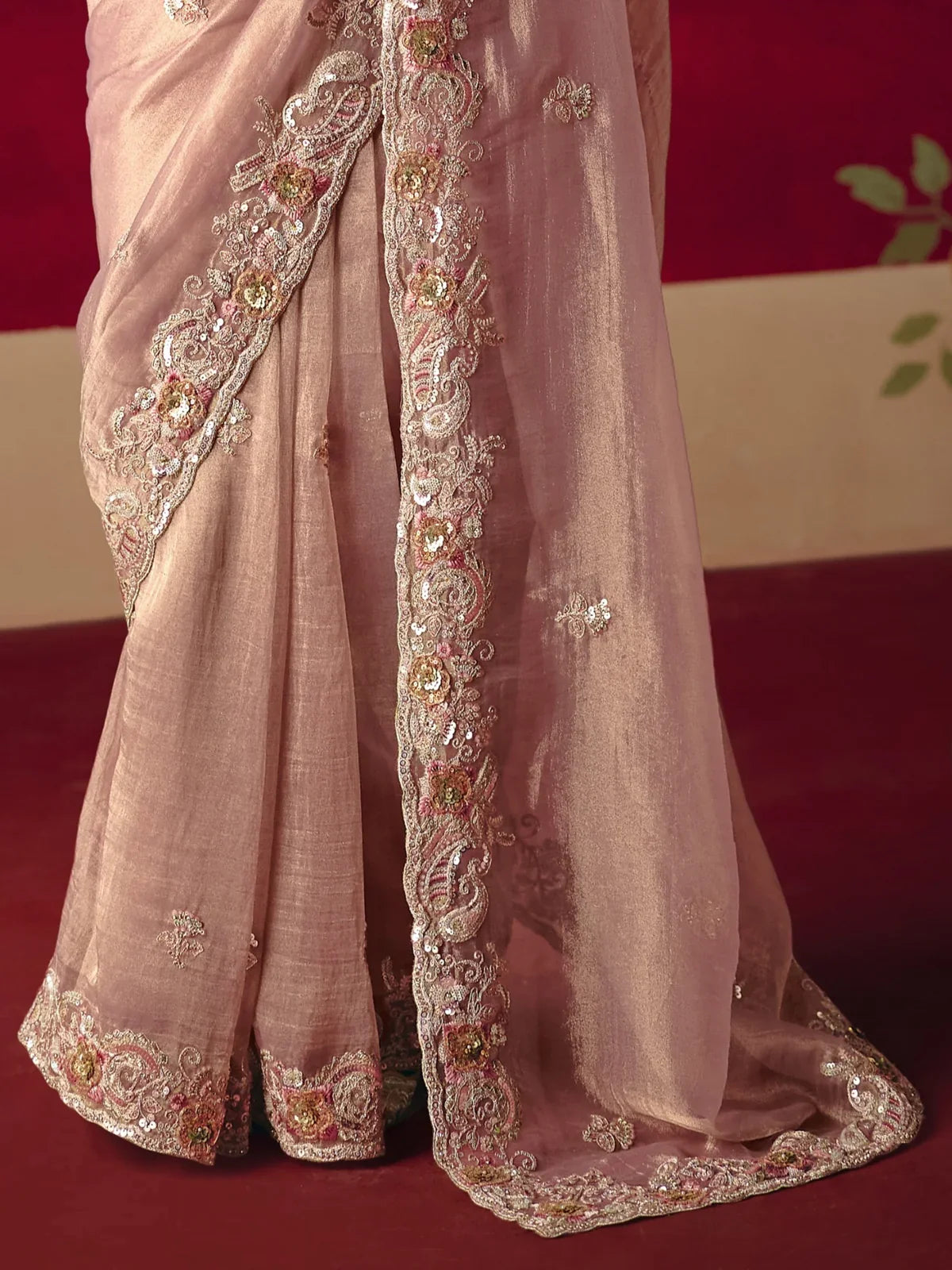 Tarani closeup of saree sequin work and embroidered border in peach tone