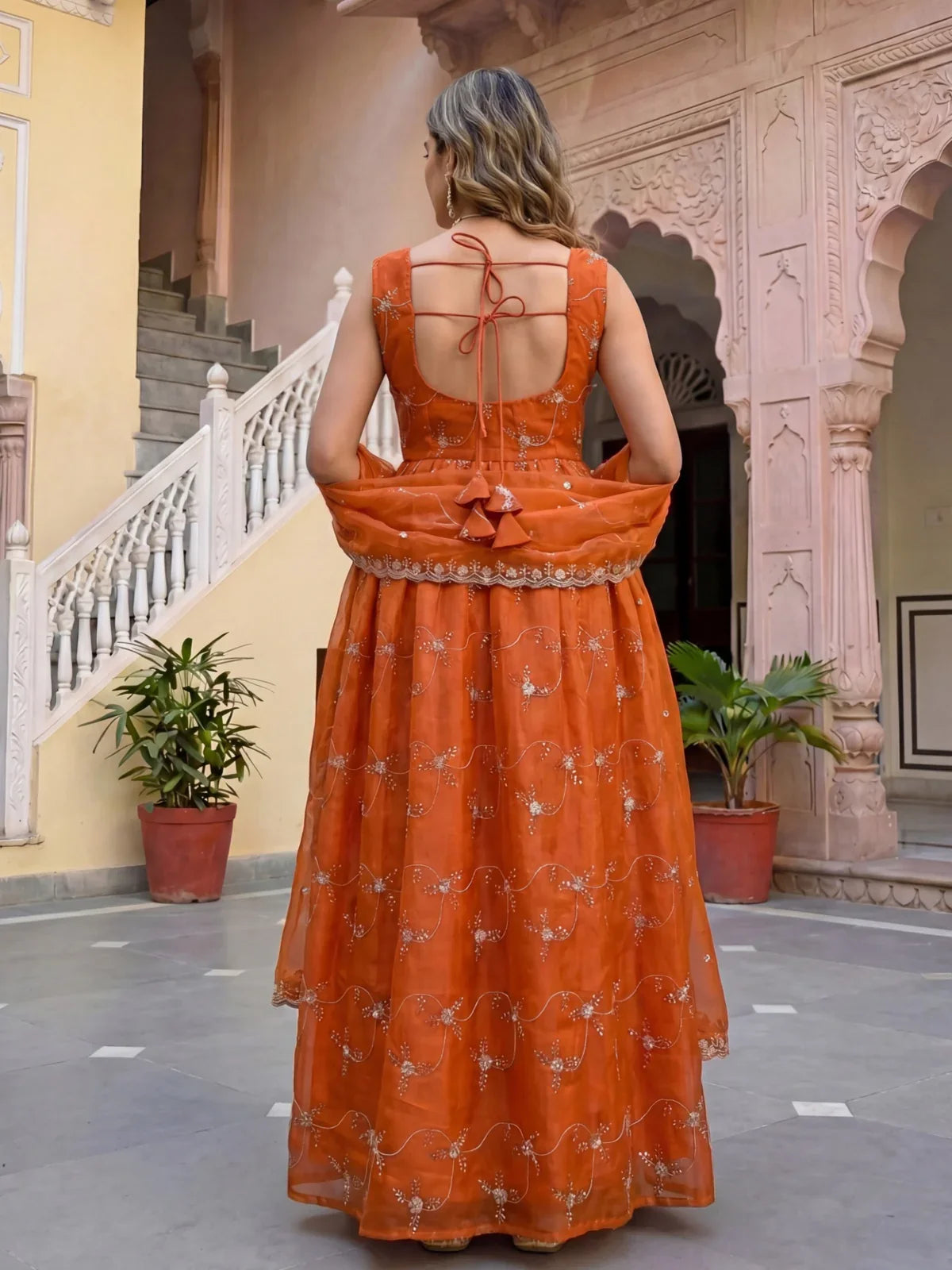 Tarani back view of orange dress with tie-up dori and embroidered dupatta fall