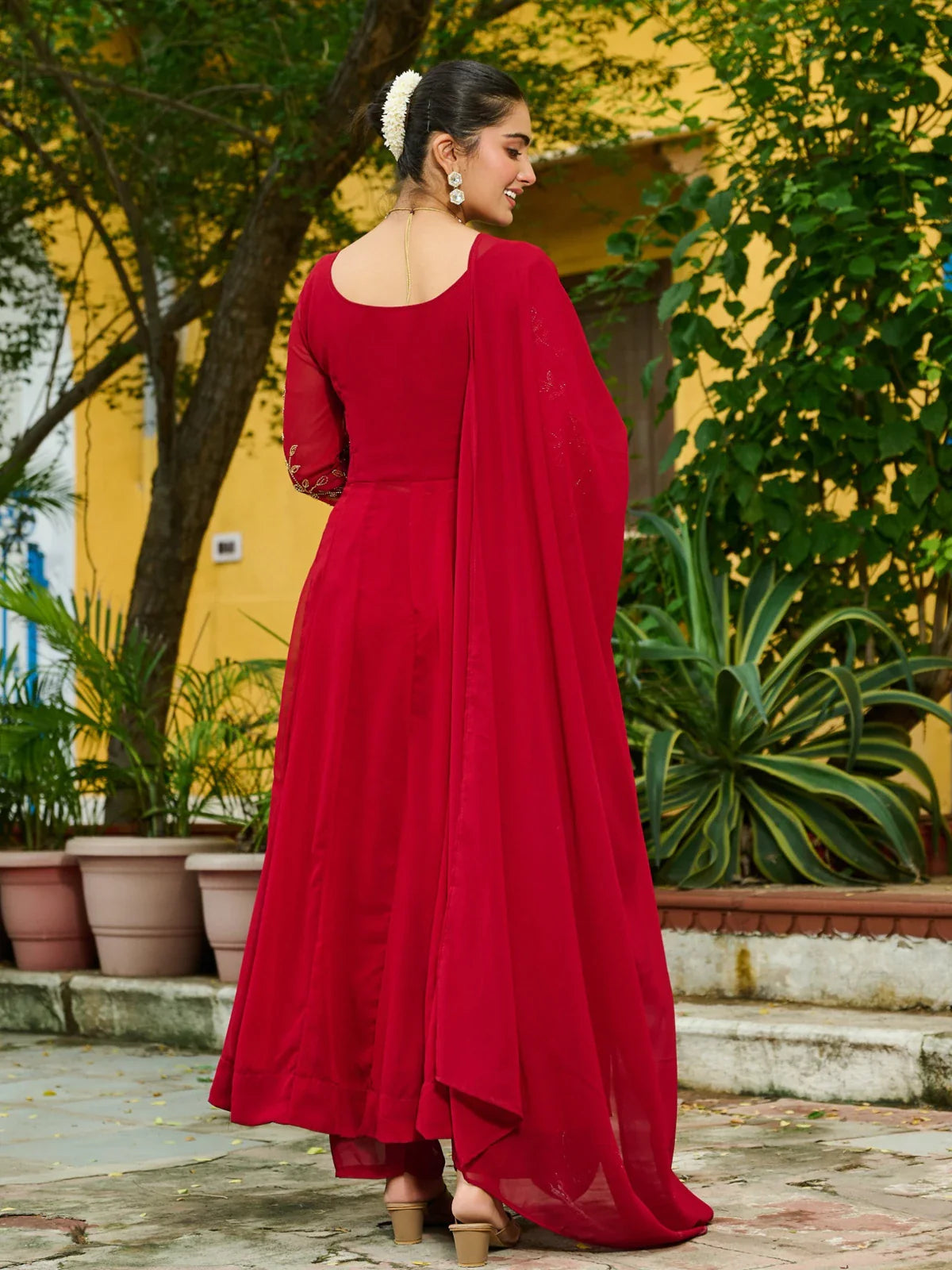 Tarani back view of red faux blooming festive dress with full dupatta drape and hairstyle