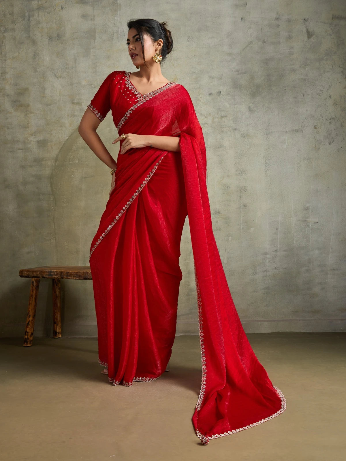 Tarani red designer saree side view with elegant chiffon drape and embellished border