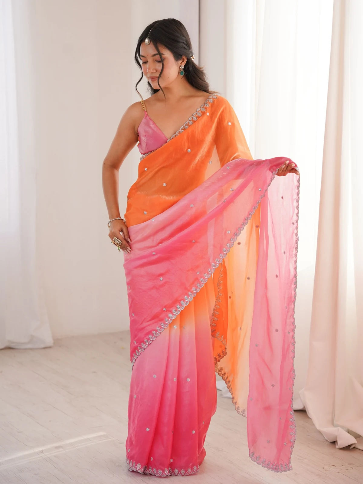 Tarani Umaira orange pink Fendy Satin saree side pose with elegant festive drape