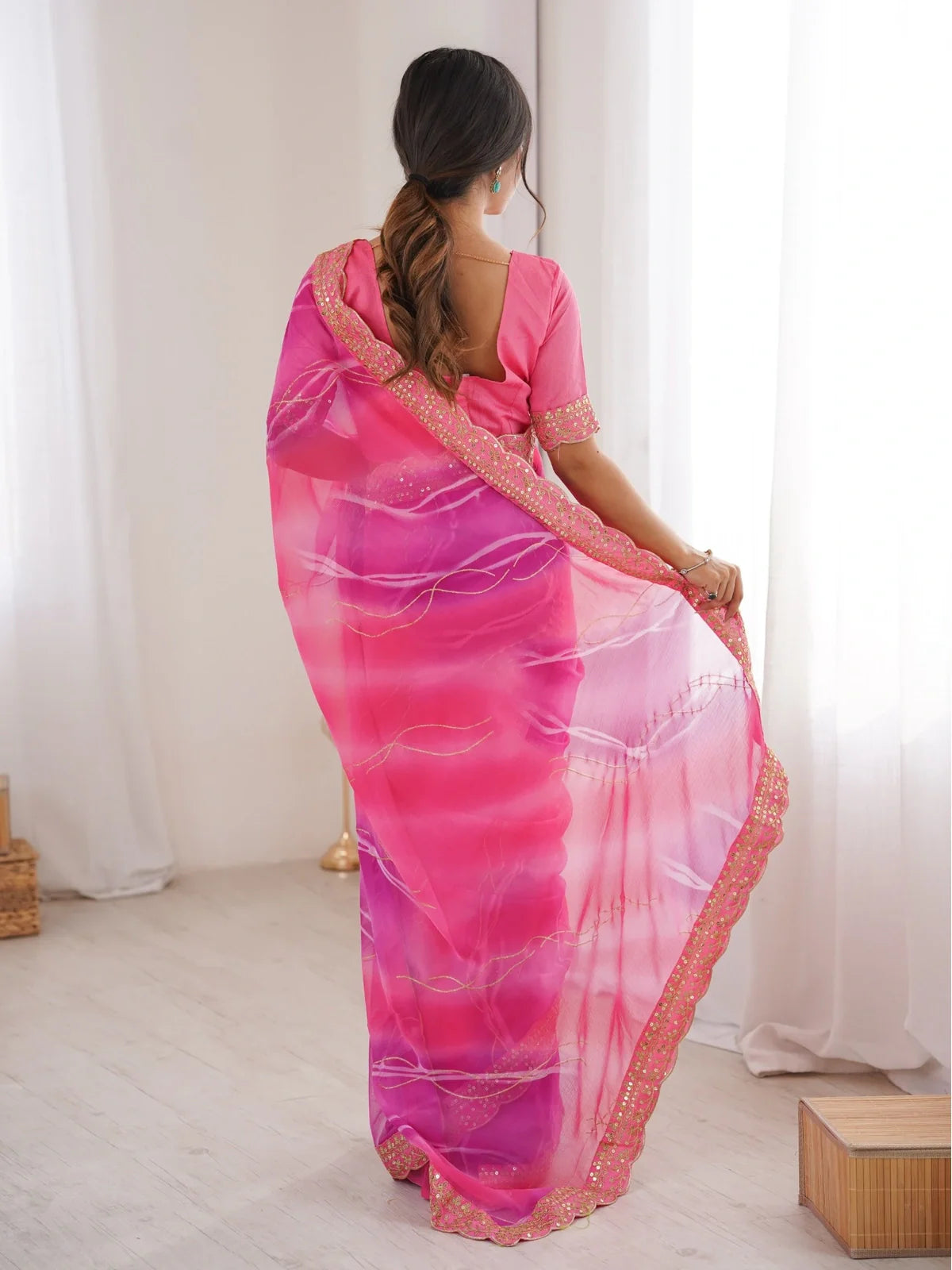 Tarani back view of georgette chiffon saree in vibrant pink with sequin border and soft drape