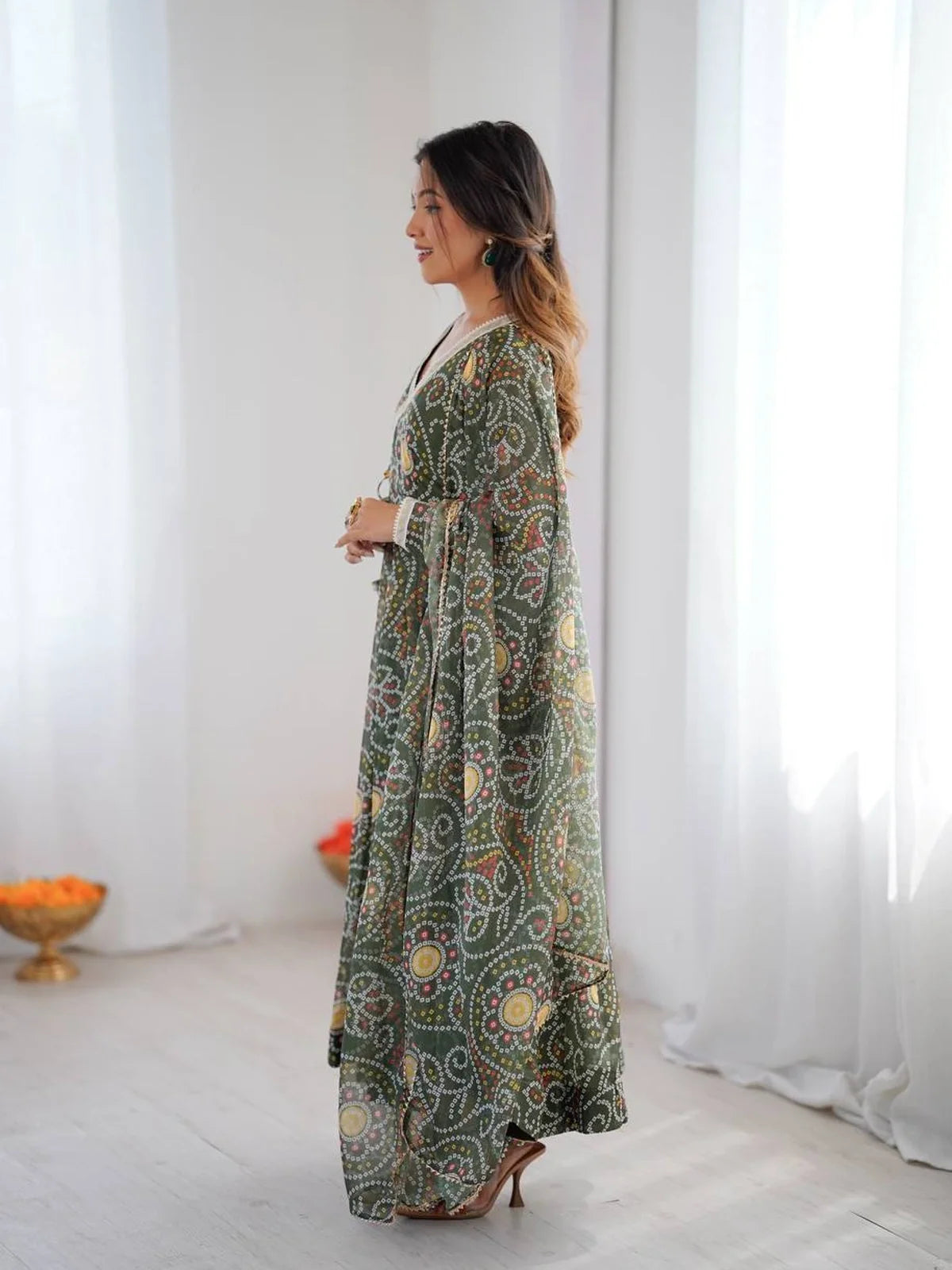 Side pose of green festive dress with printed flow and dupatta by Tarani