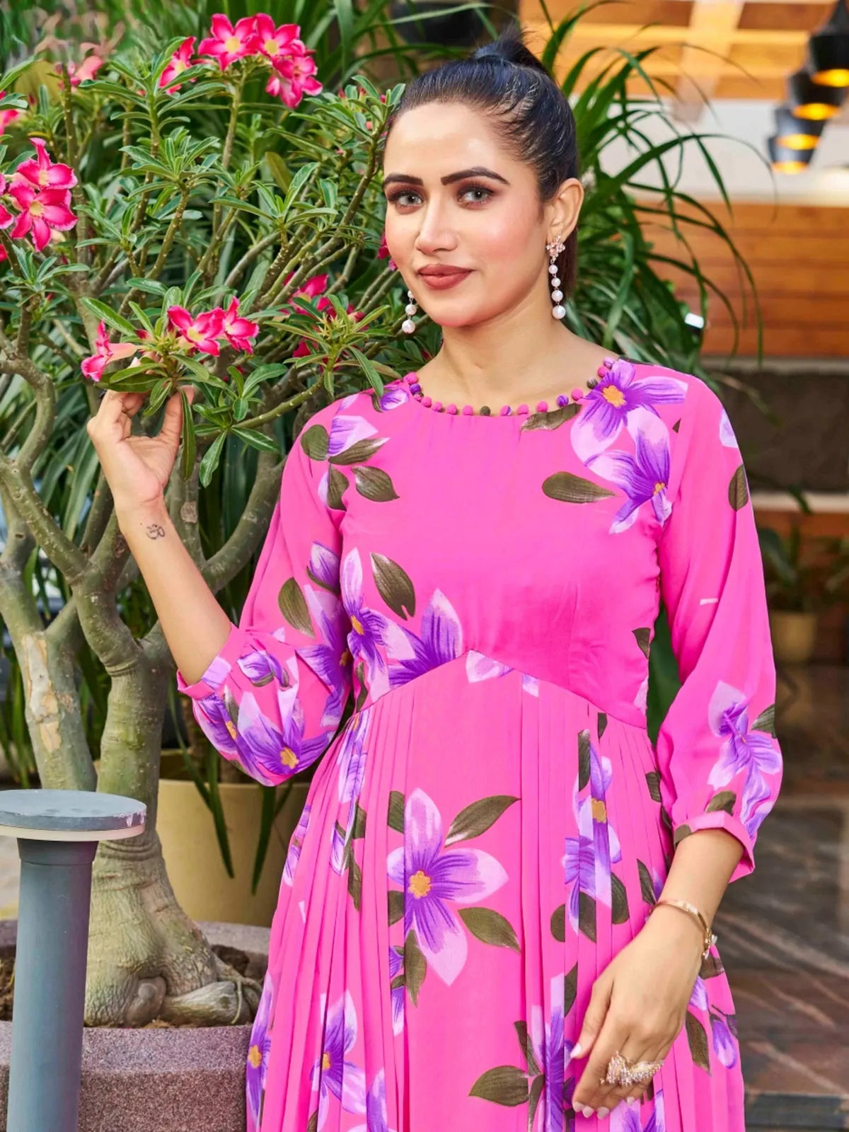 Tarani upper body view of pink georgette dress with floral detailing and round neckline