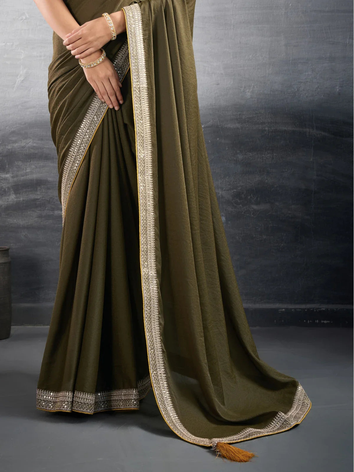 Tarani olive green georgette saree pallu view showcasing intricate border and fall detailing