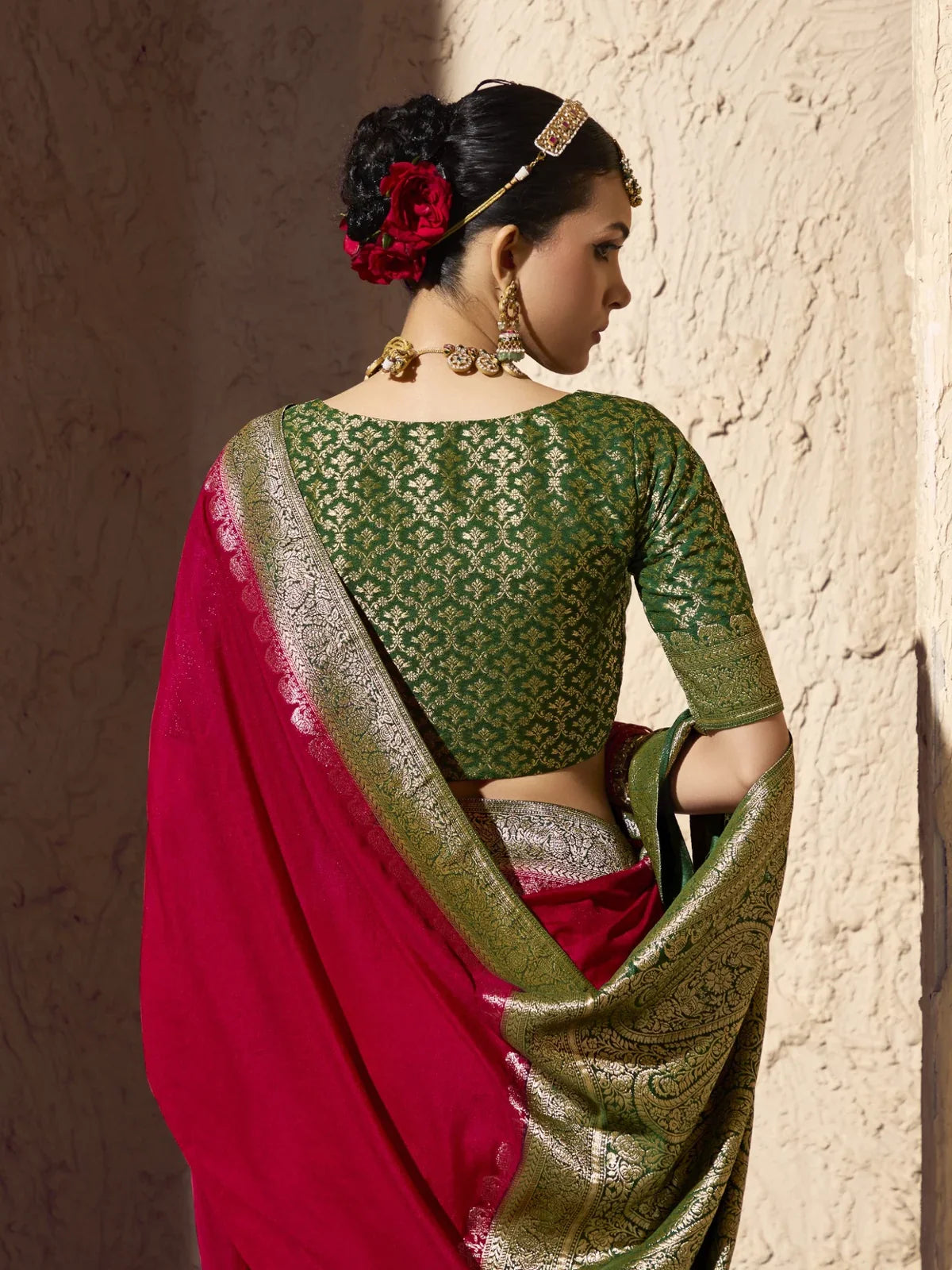 Tarani green blouse back view with zari work styled with pink georgette saree