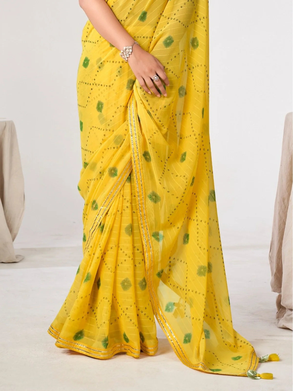 Tarani yellow georgette saree with delicate border and soft flow perfect for parties