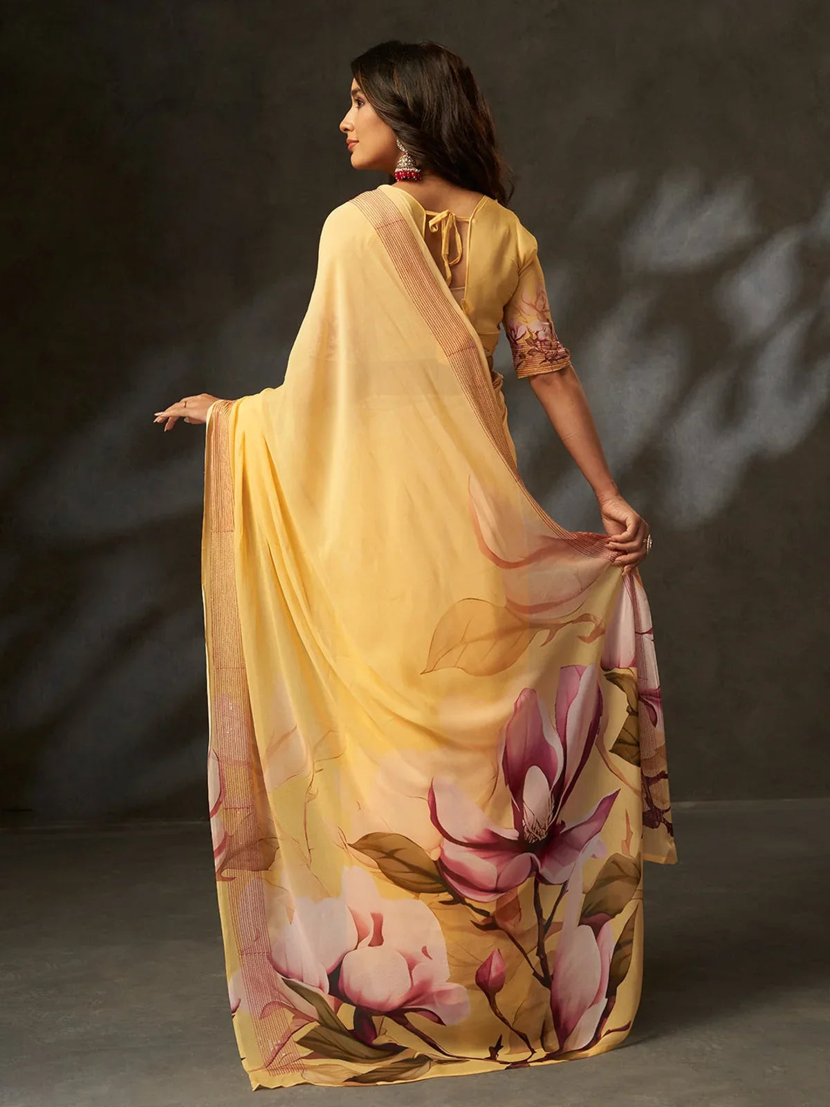 Back view of Tarani yellow saree with floral printed pallu and plain back blouse design
