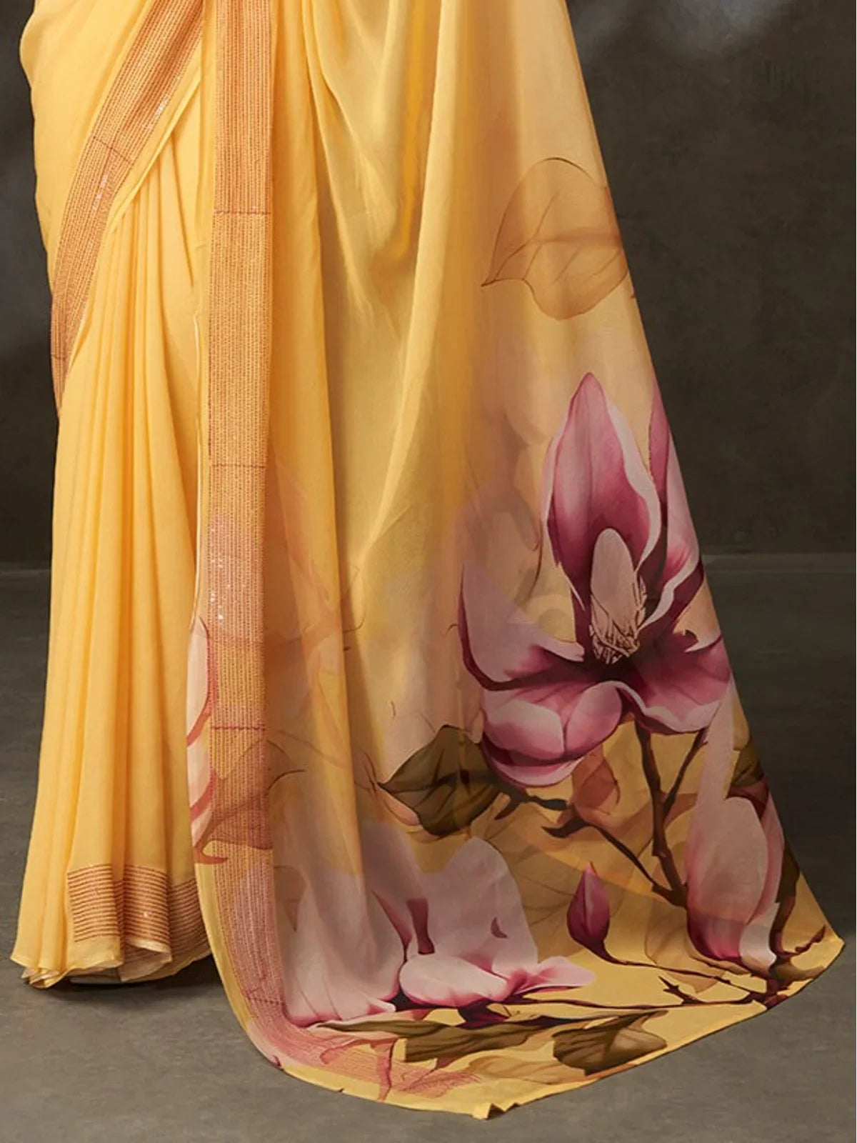 Tarani saree pallu closeup showing large pink floral print on soft yellow georgette silk fabric