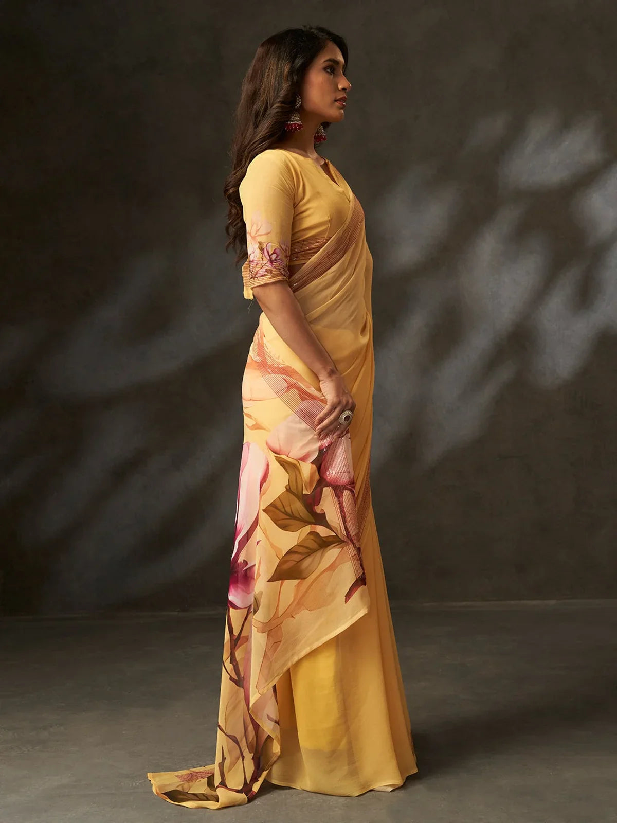 Side profile of Tarani yellow georgette saree with floral pallu flow and sleeve detail