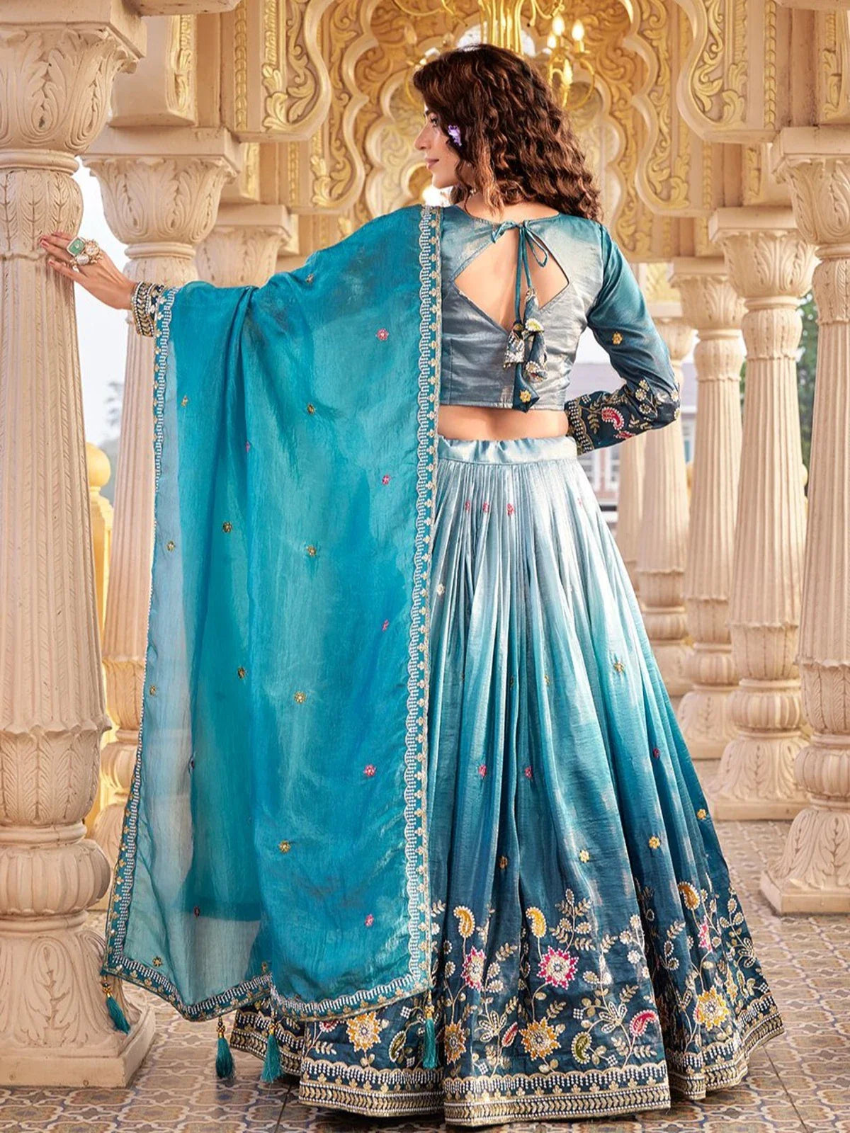 Back side of Tarani lehenga showing designer blouse and dupatta drape in blue shade