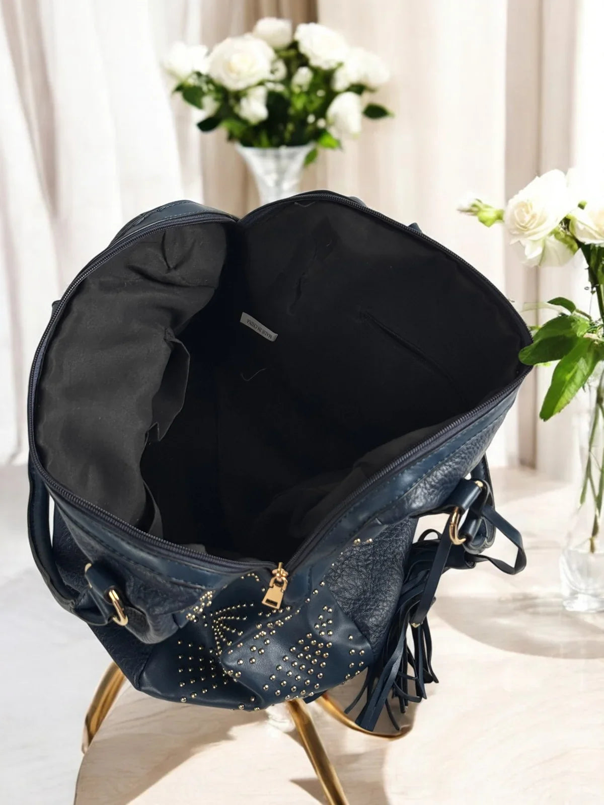 Tarani inside view of spacious navy blue PU leather handbag with compartments