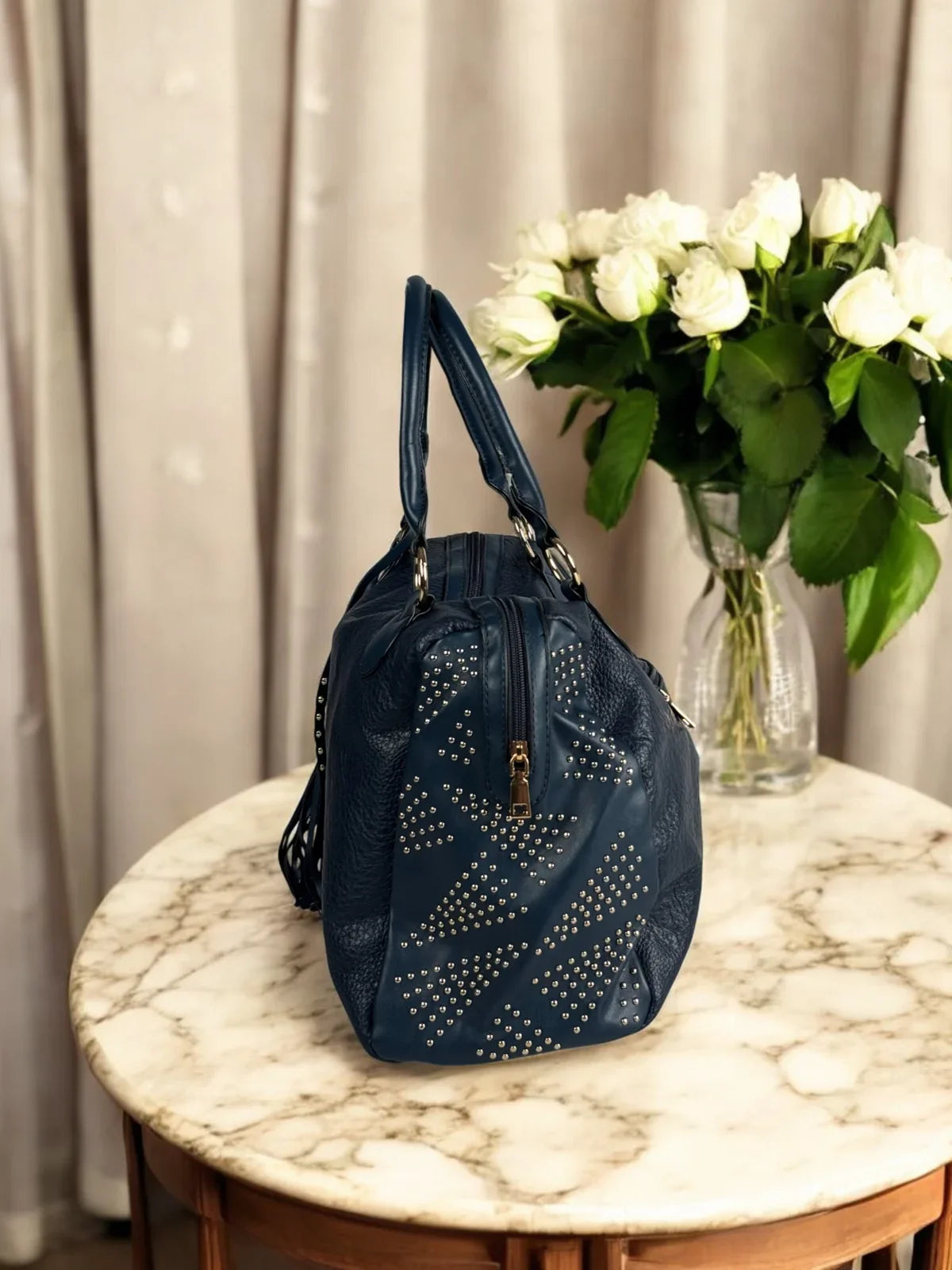 Tarani side view of navy blue PU leather handbag with studded design