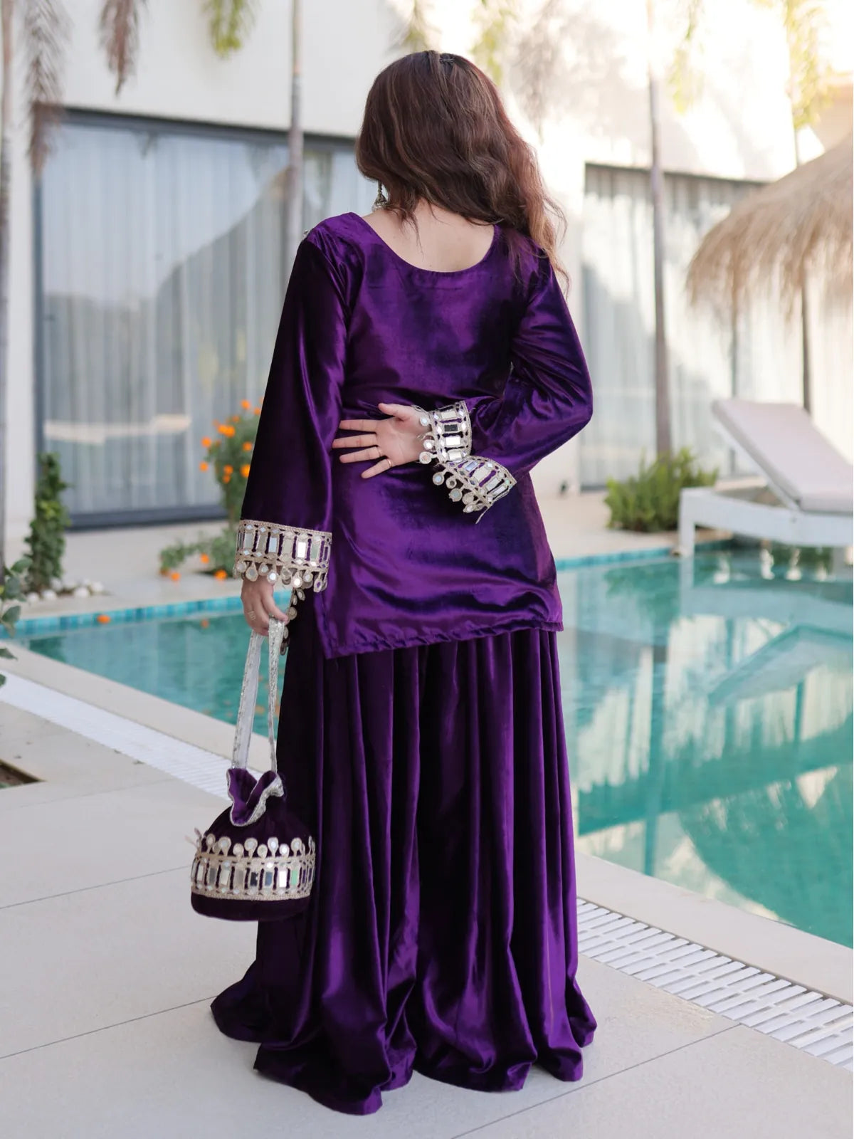 Tarani back view of purple velvet dress with mirror detailed sleeves and traditional design
