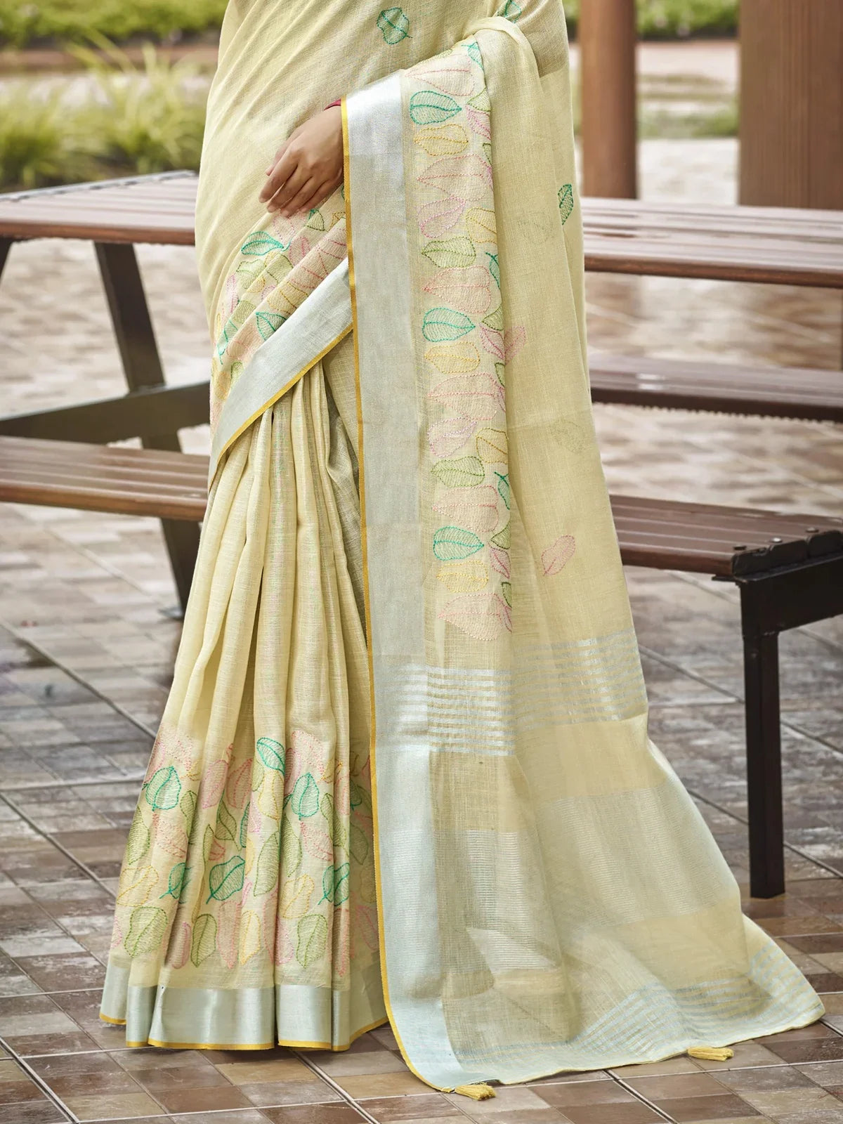 Tarani beige linen saree pallu view with intricate pastel leaf embroidery details