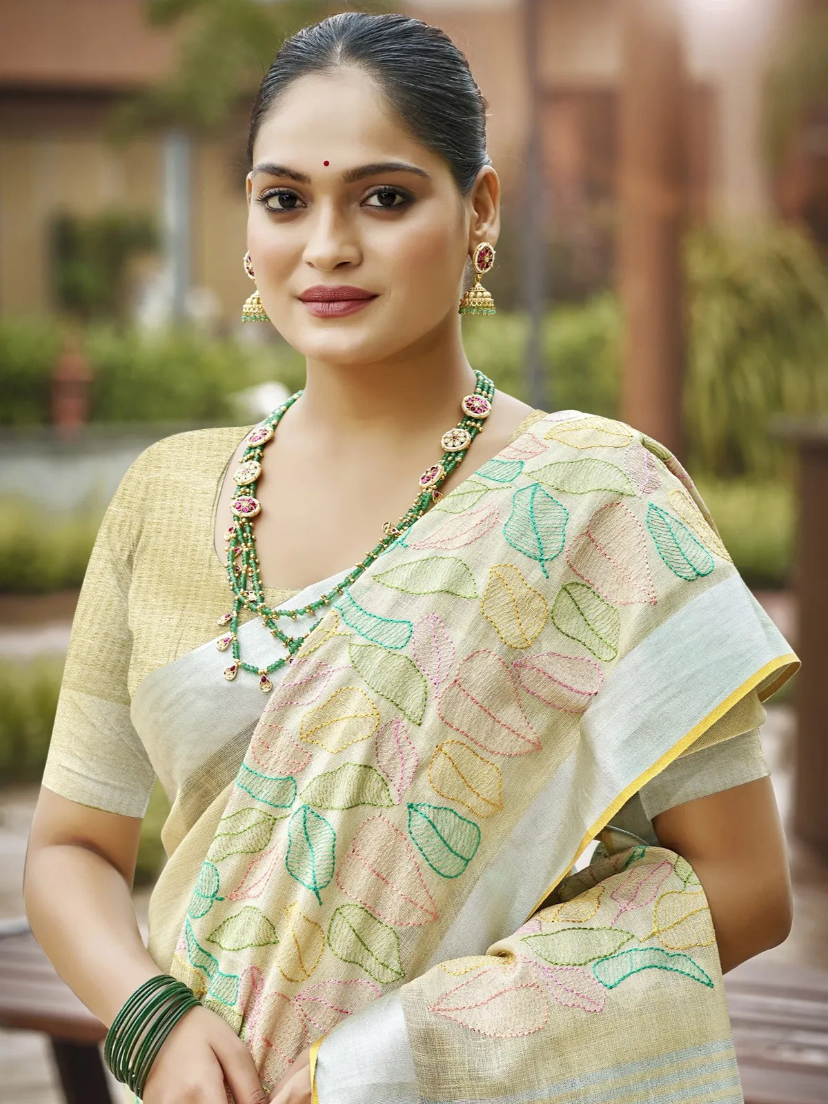 Tarani beige linen saree upper body view highlighting pallu and jewelry styling