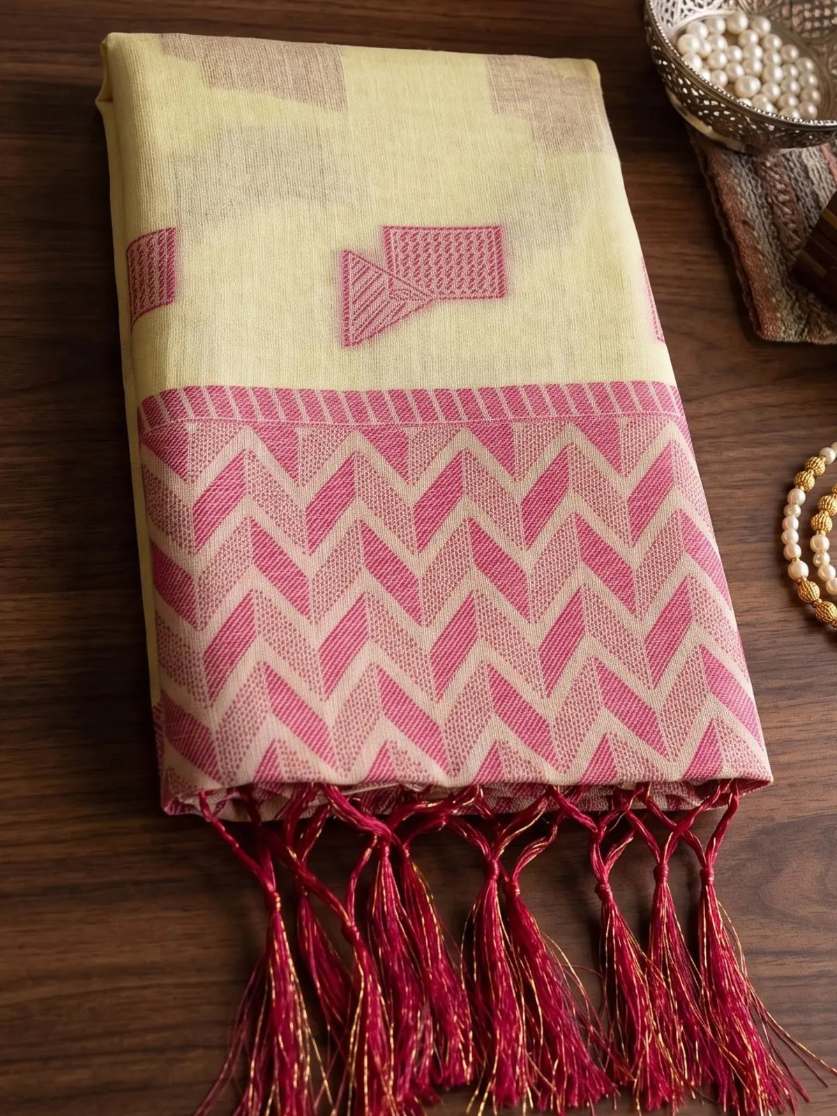 Tarani cream linen cotton saree closeup showing geometric woven border and tassel detailing