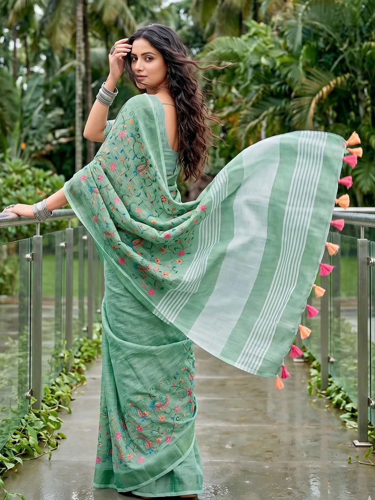 Tarani green linen saree back view with flowing pallu and embroidery work