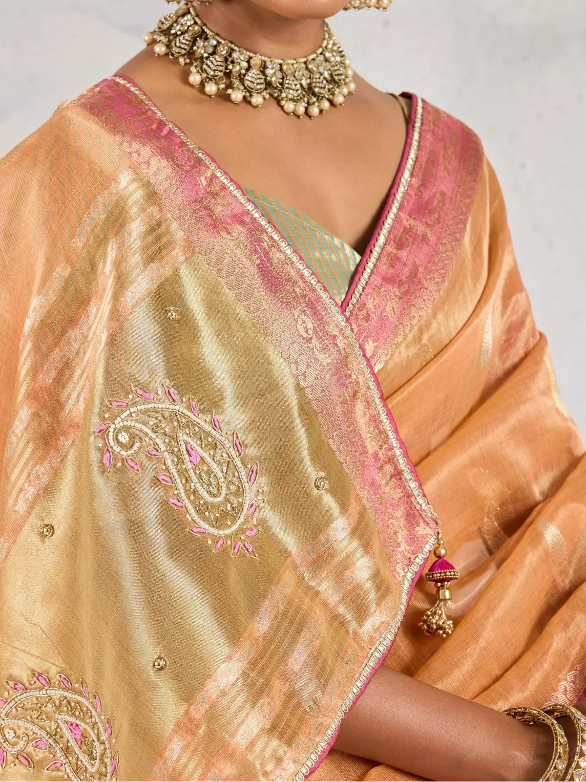 Tarani close pallu view of orange linen saree with zari work paisley motifs and golden shimmer
