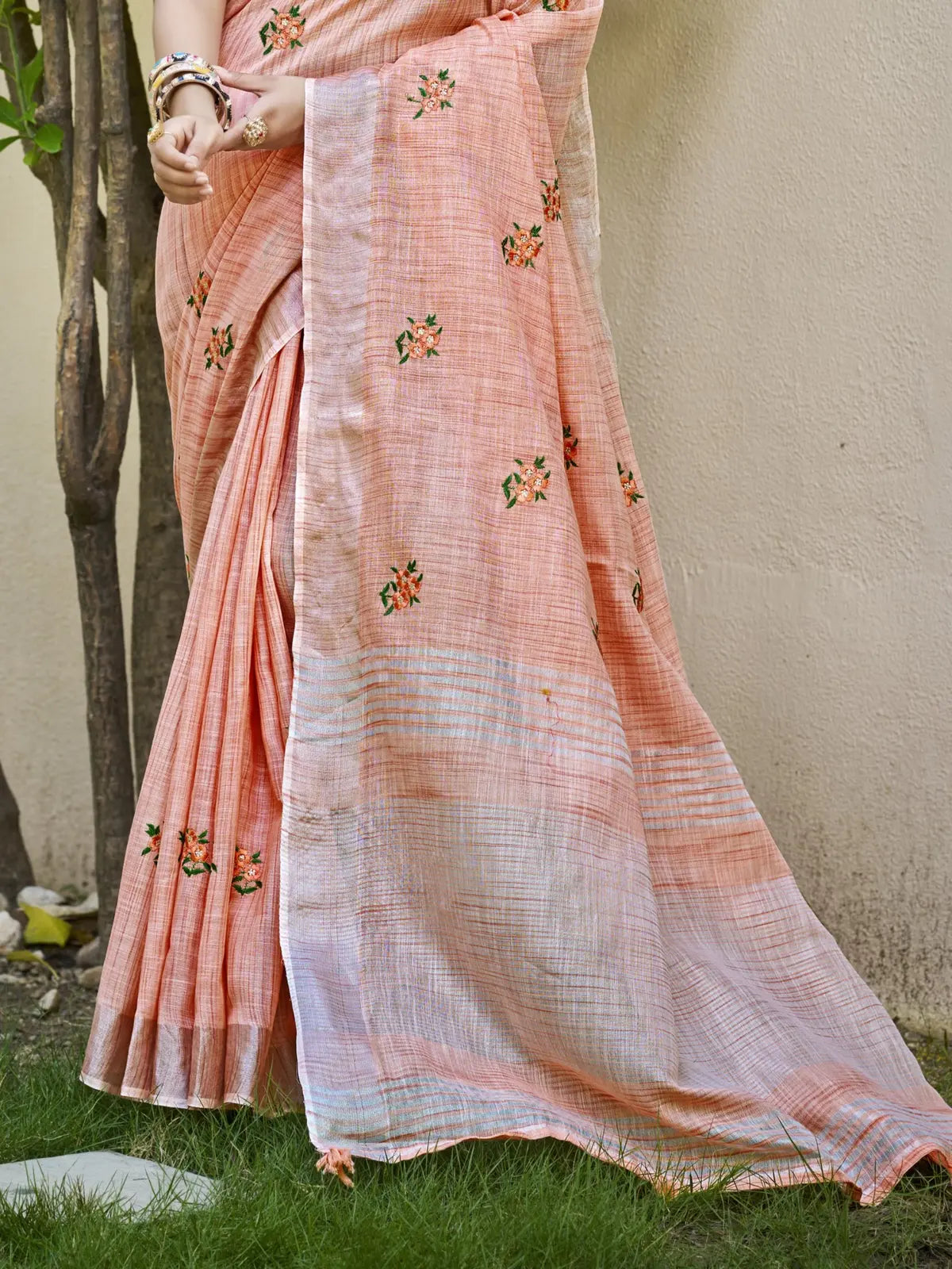 Tarani peach linen saree close pallu view with floral embroidery and detailing